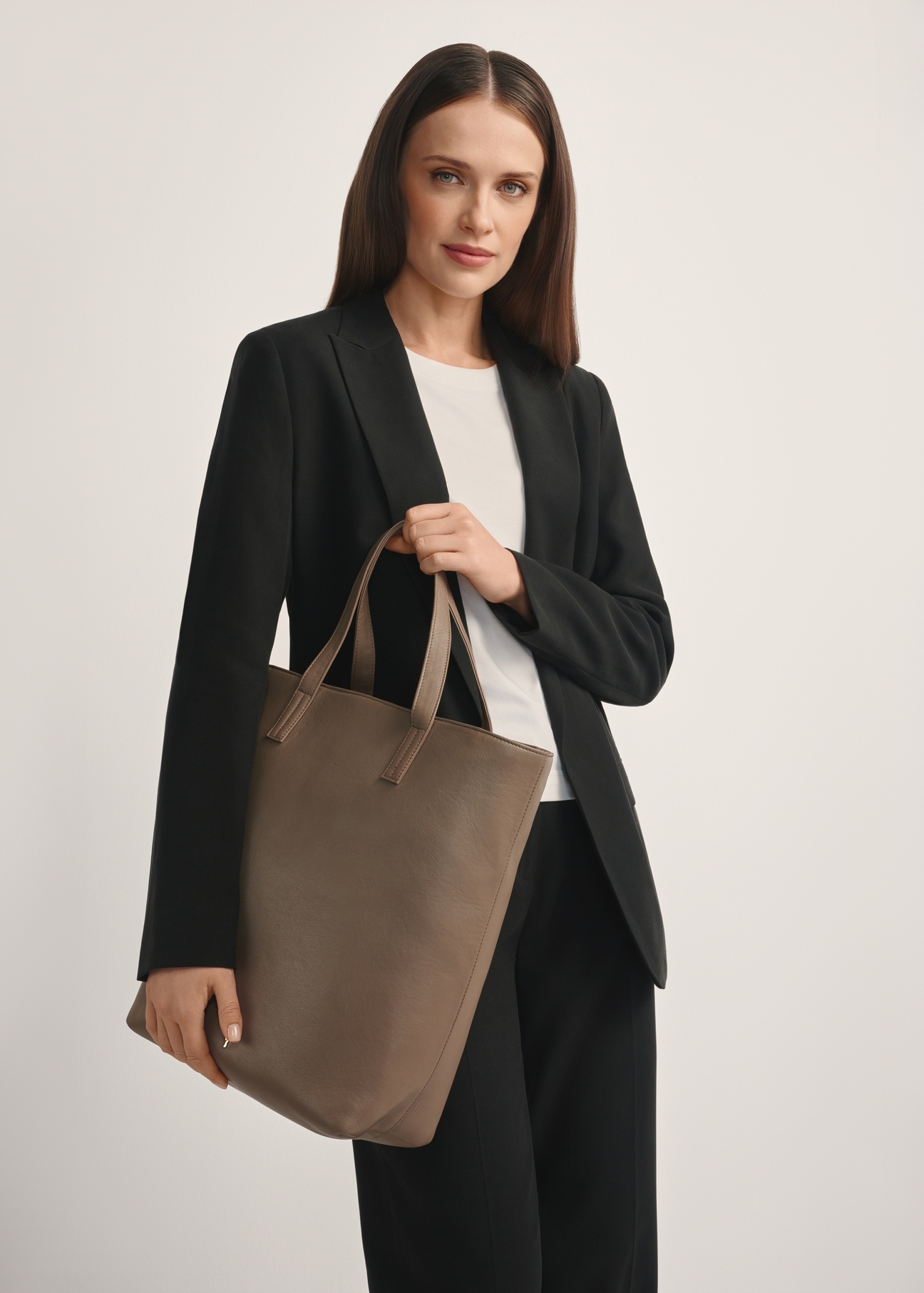 Duża beżowa torebka damska shoppper TORES-0850F-1K(W26), widok produktu skosem na modelce, widoczna połowa sylwetki.