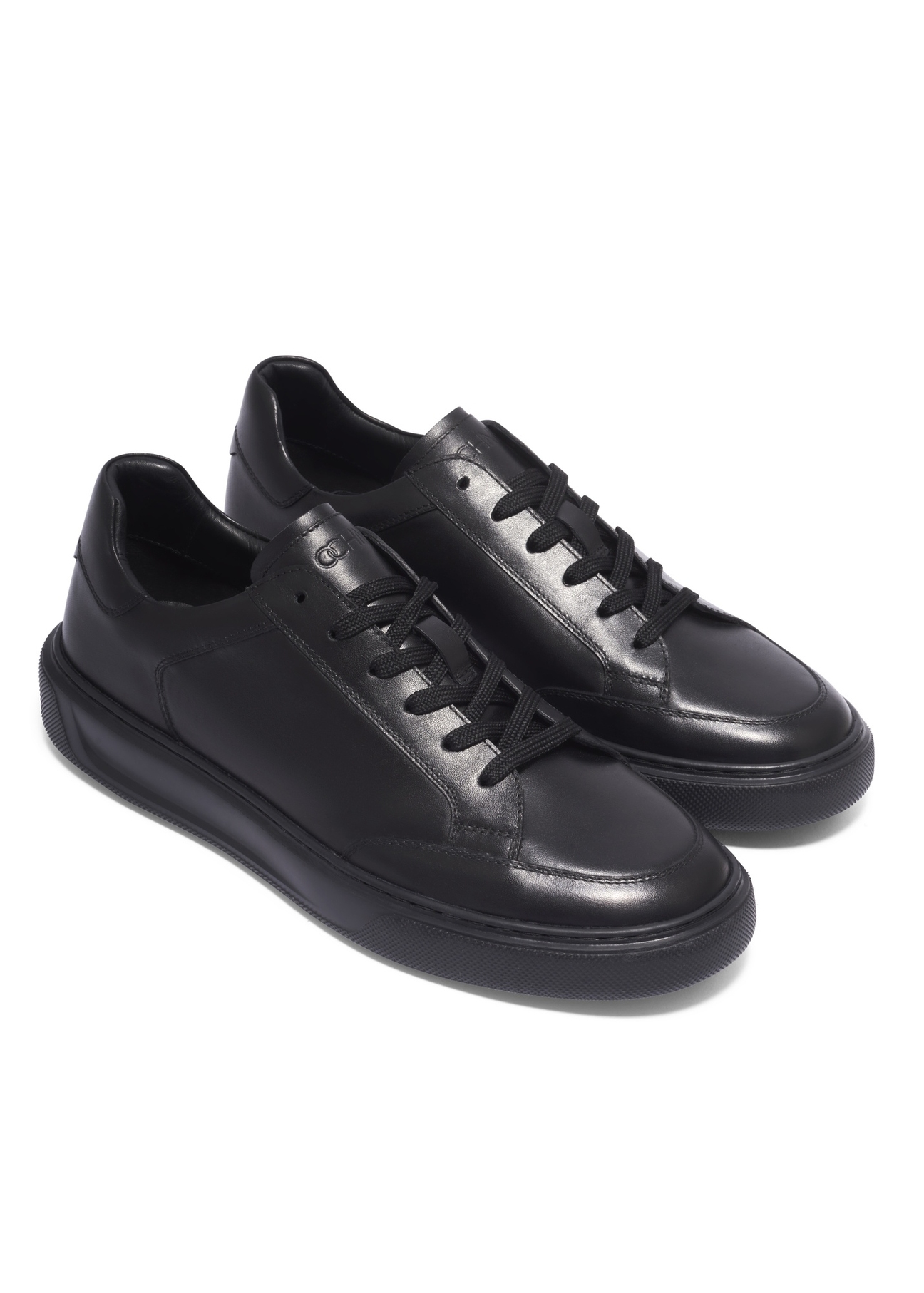 Czarne skórzane buty sportowe męskie BUTYM-0574-99(Z26), widok produktu skosem na białym tle.