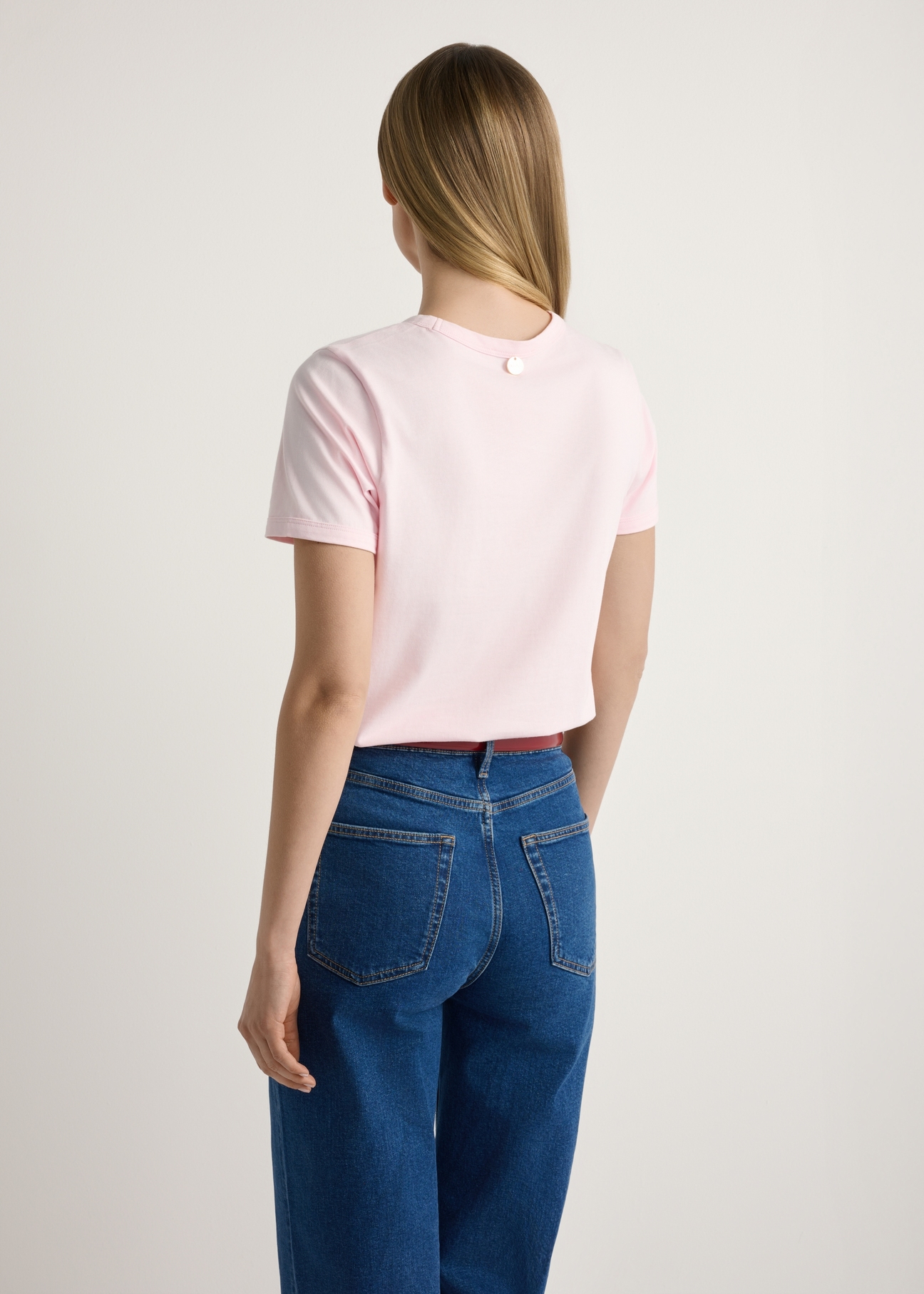 Różowy T-shirt damski z nadrukiem TSHDT-0152-5A(W26), widok produktu od tyłu na modelce, widoczna połowa sylwetki.
