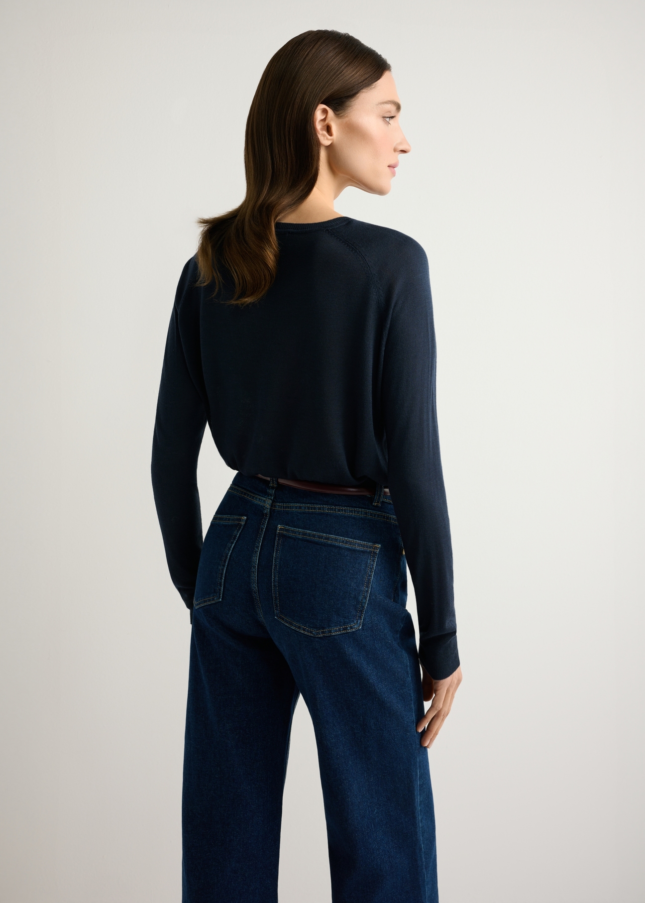 Cienki granatowy sweter damski SWEDT-0257-7E(W26), widok produktu od tyłu na modelce, widoczna połowa sylwetki.