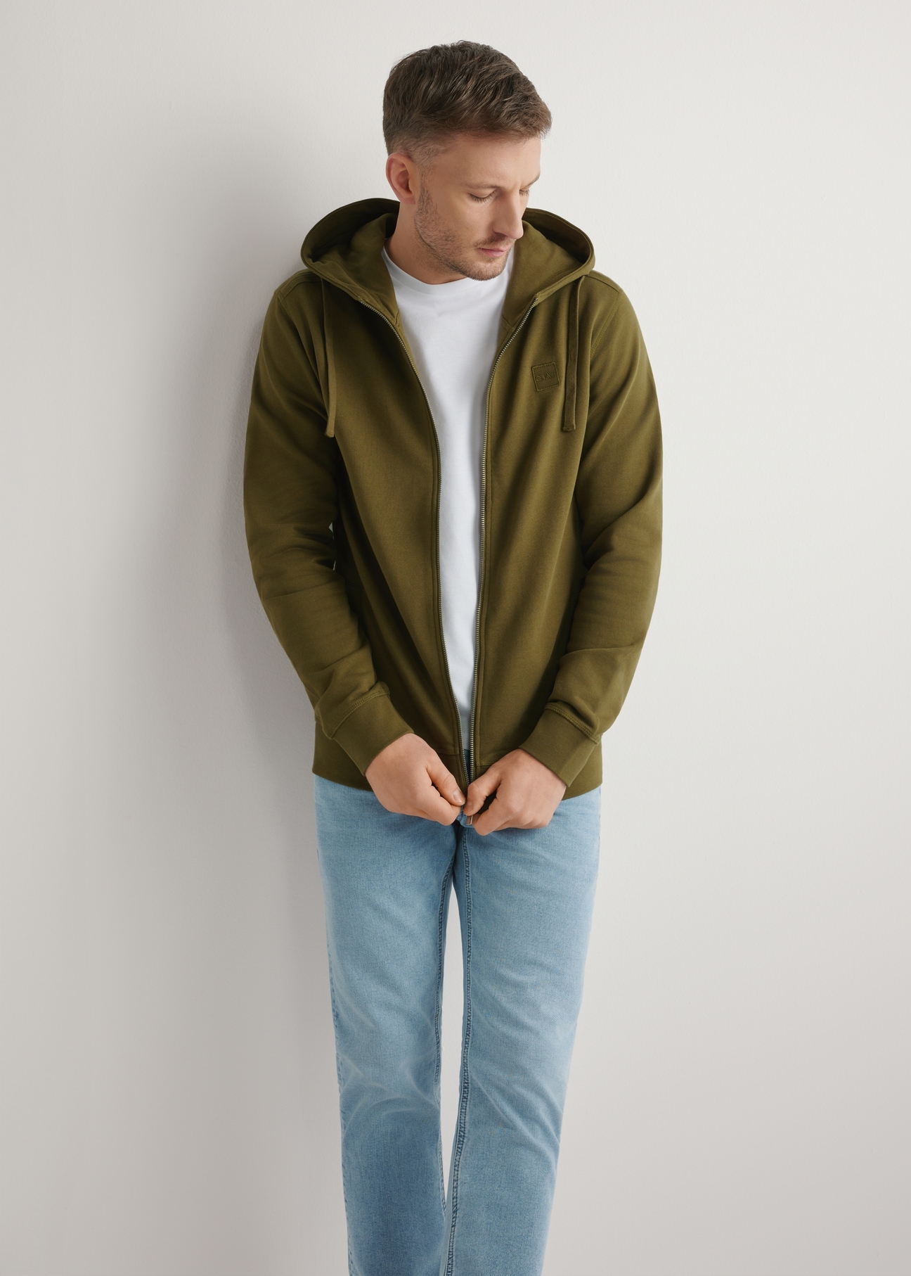 Bluza męska z suwakiem w kolorze khaki BLZMT-0078-8D(W26), widok produktu z przodu na modelu. Widoczna połowa sylwetki.