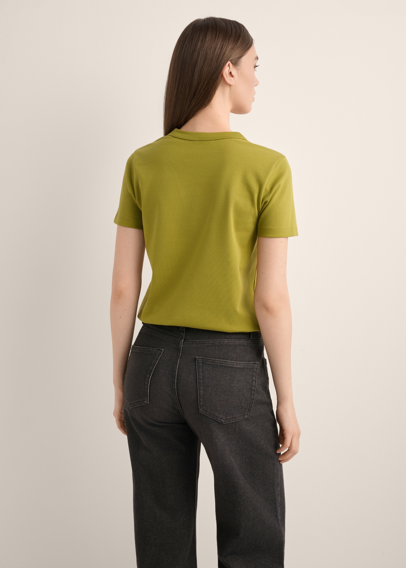 Oliwkowy bawełniany T-shirt damski TSHDT-0144-8E(Z26), widok produktu od tyłu na modelce. Widoczna połowa sylwetki.
