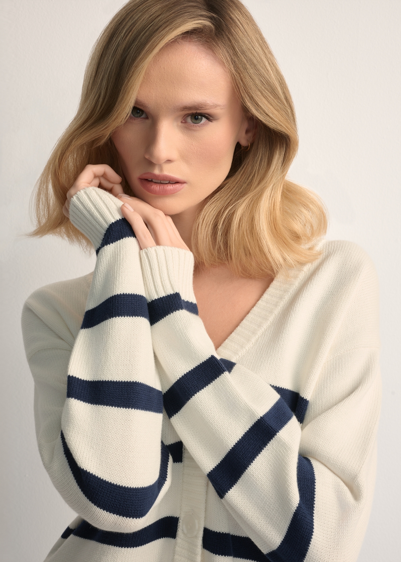Kremowy kardigan damski w paski KARDT-0060-0P(W26), zbliżenie na detal produktu na modelce.