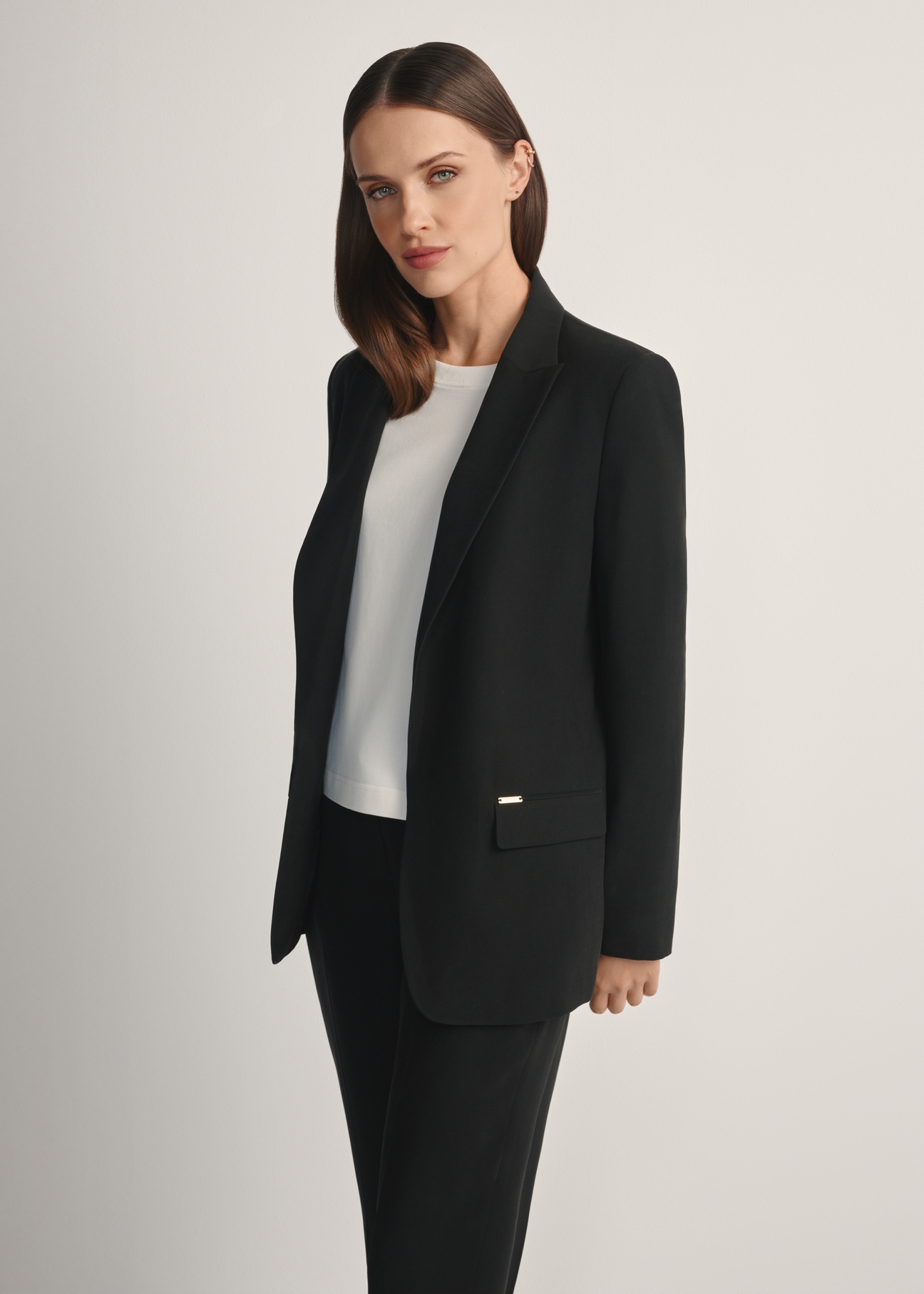 Marynarka damska w kolorze czarnym ZAKDT-0031A-99(W26), widok produktu z przodu na modelce. Widoczna połowa sylwetki.
