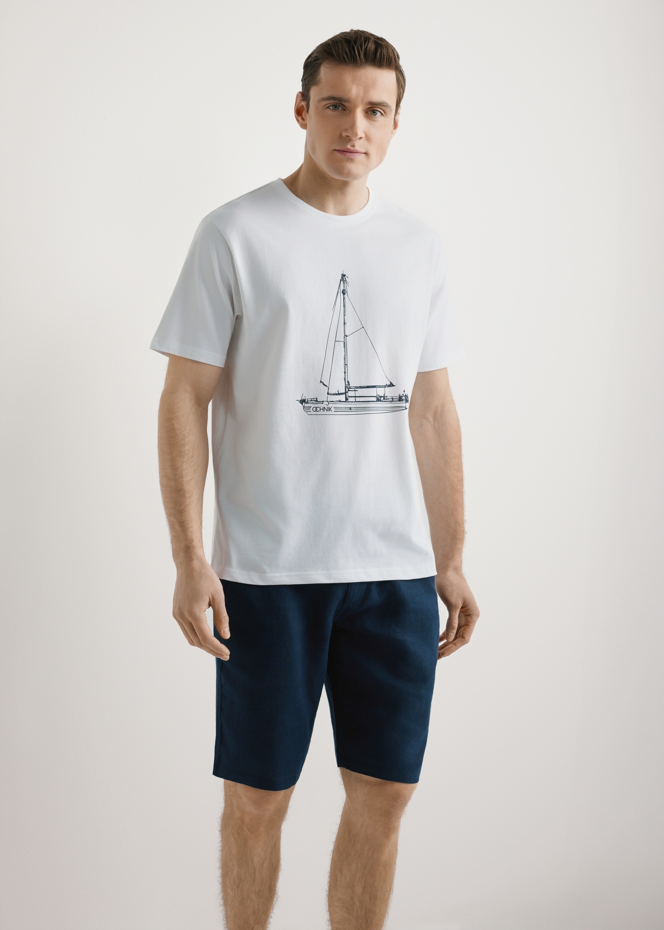  Biały T-shirt męski z nadrukiem TSHMT-0145-0A(W26), widok produktu z przodu na modelu. Widoczna połowa sylwetki.
