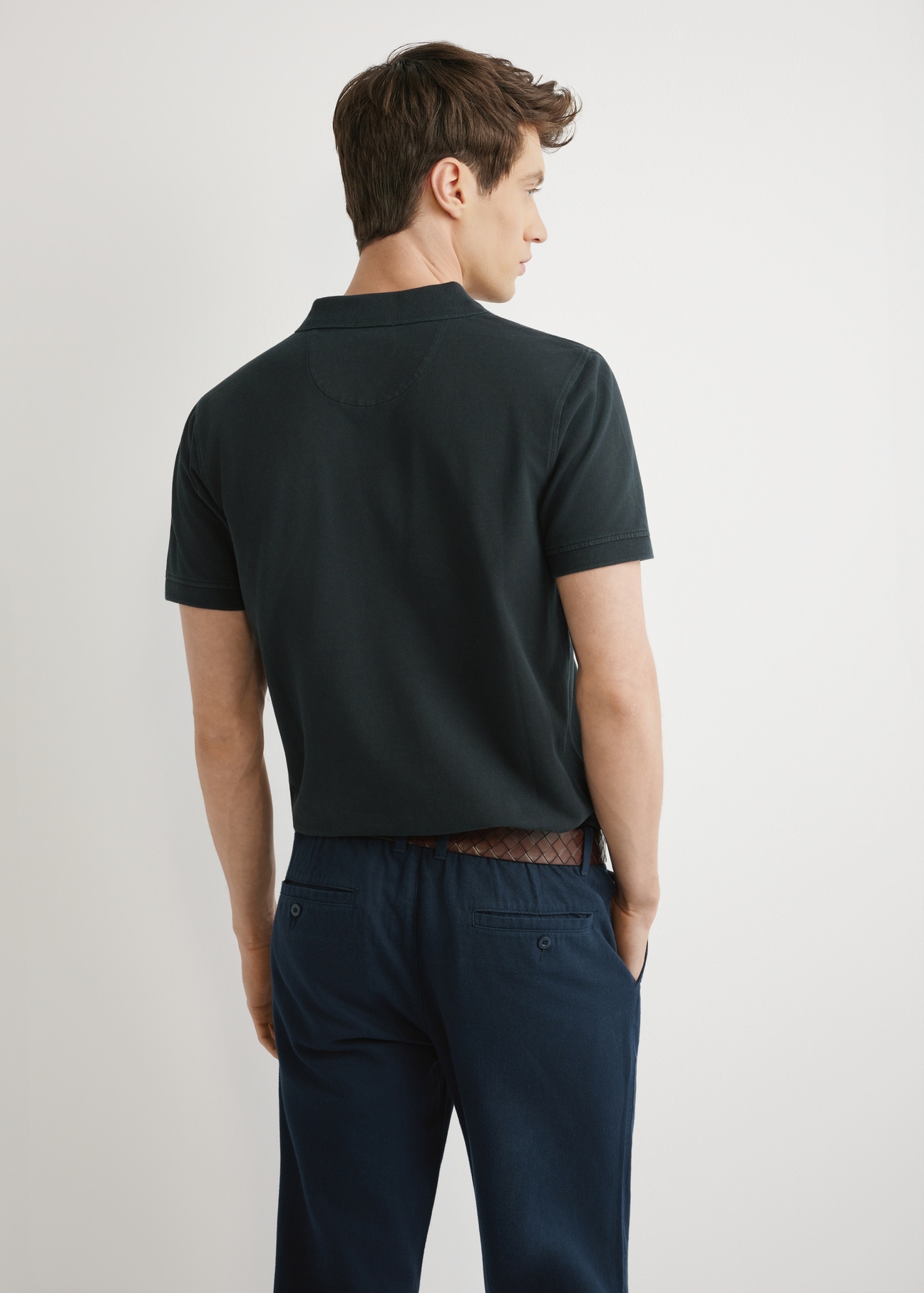 Męska koszulka polo w kolorze czarnym POLMT-0055A-99(W26), widok produktu z tyłu na modelu. Widoczna połowa sylwetki.