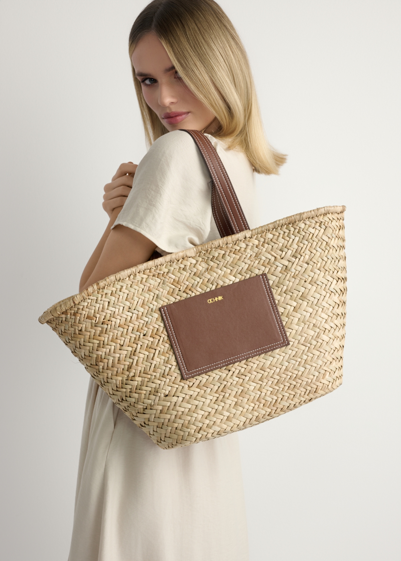 Słomkowa torebka damska typu shopper TOREC-1219-1E(W26), widok produktu z przodu, na modelce, na jasnym tle. 