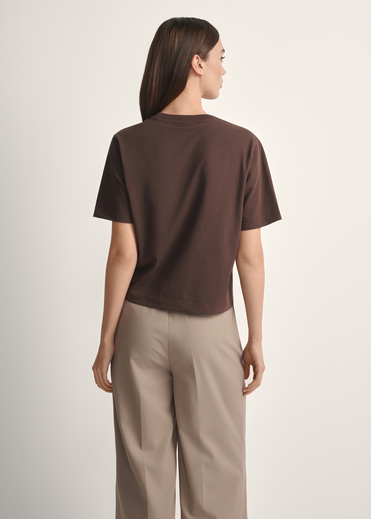 Bawełniany brązowy T-shirt damski TSHDT-0138-1I(W26), widok produktu od tyłu na modelce, widoczna połowa sylwetki.