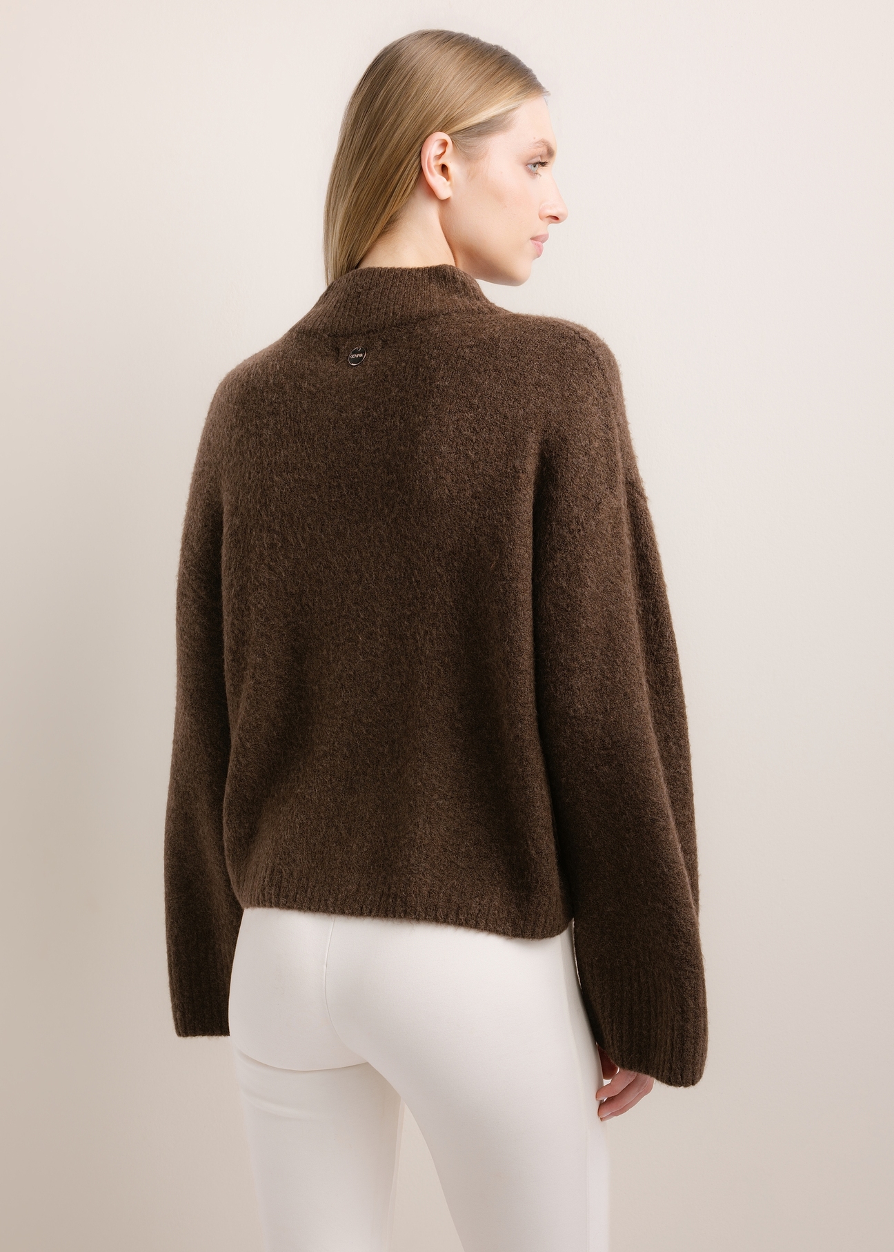 Ciemnobrązowy sweter damski oversize SWEDT-0270-1I(Z26), widok produktu od tyłu na modelce. Widoczna połowa sylwetki.