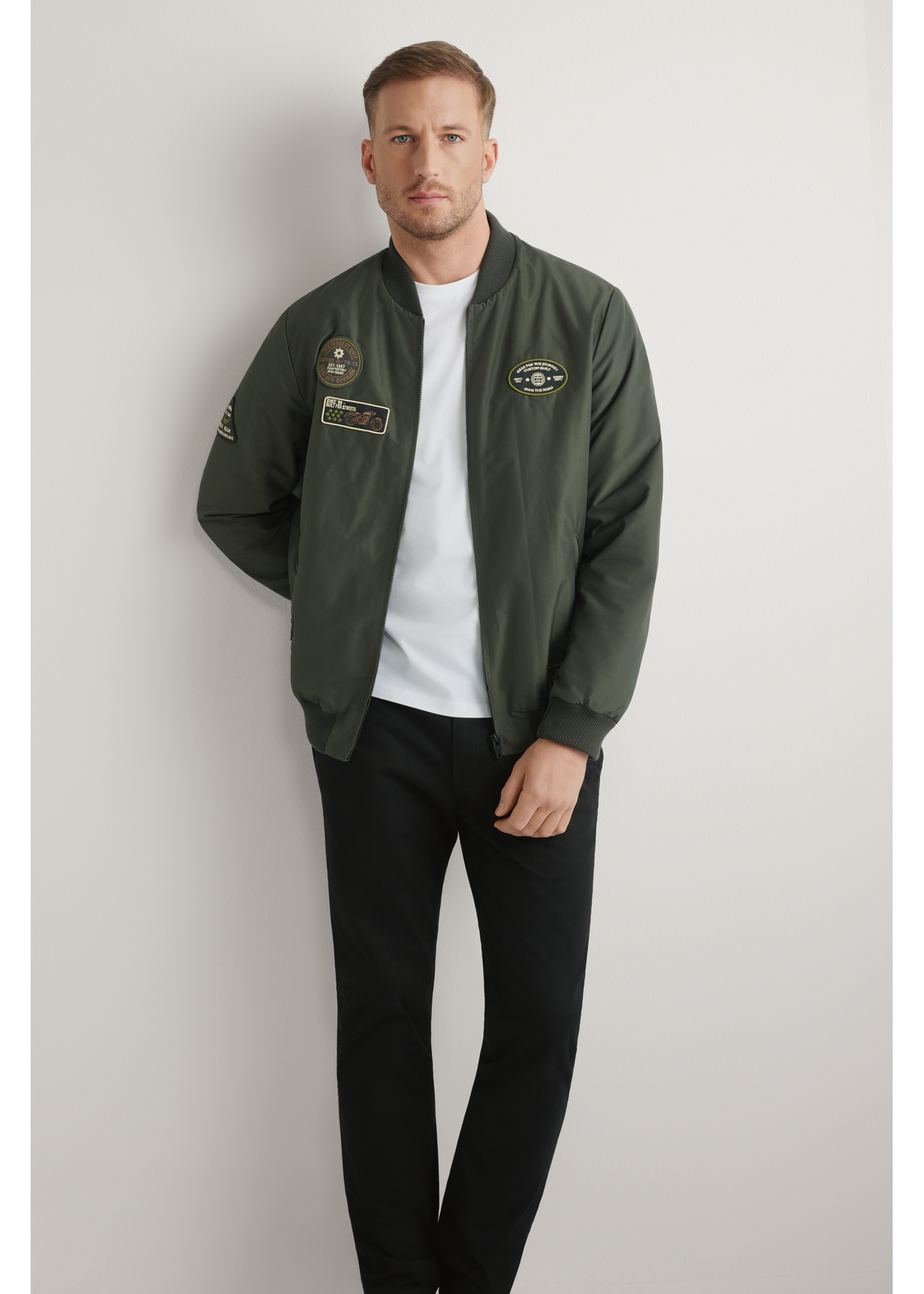 Kurtka bomberka męska w kolorze khaki KURMT-0413A-8D(W26) - widok produktu z przodu na, na jasnym tle. Widoczna cała sylwetka.