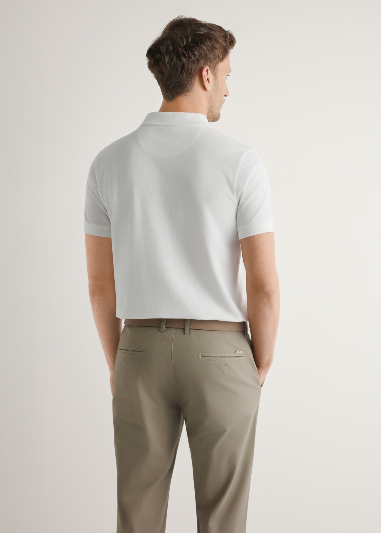 Kremowa koszulka polo z bawełny POLMT-0086-0B(W26), widok produkt z tyłu na modelu. Widoczna połowa sylwetki.