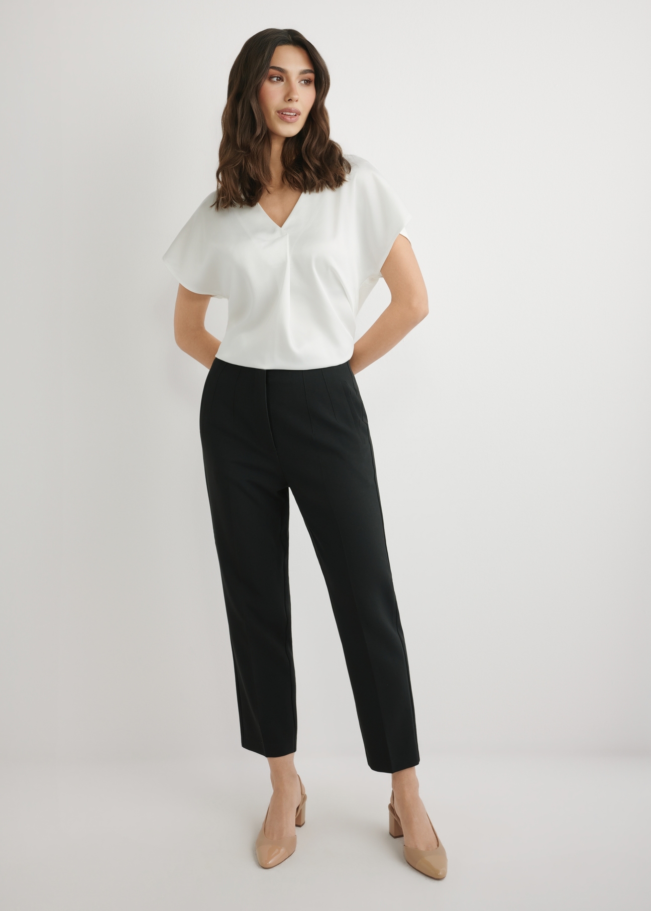 Czarne eleganckie spodnie damskie SPODT-0109-99(W26), widok produktu z przodu na modelce. Widoczna cała sylwetka.