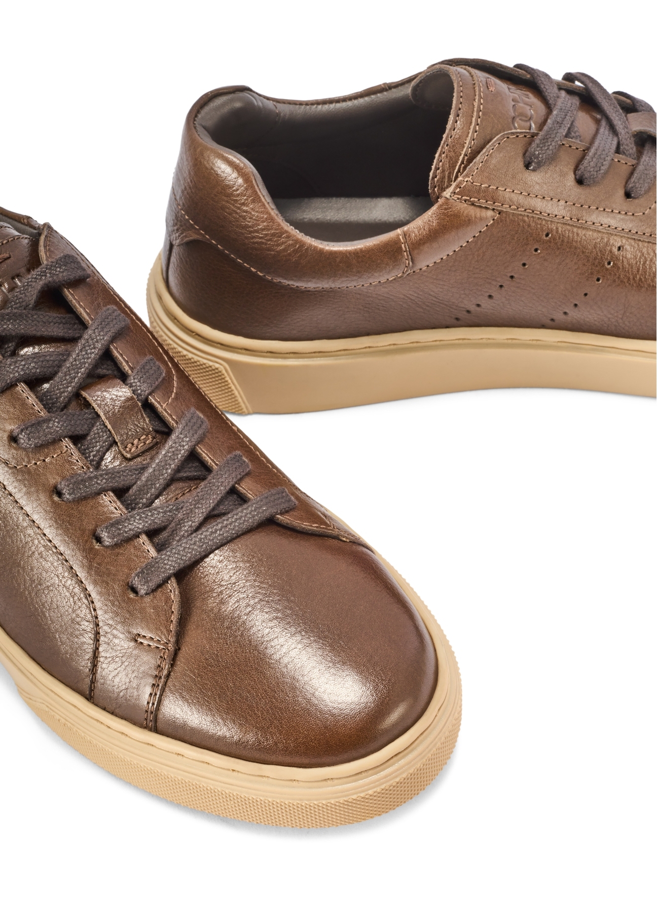 Ciemnobrązowe skórzane sneakersy męskie BUTYM-0486-1I(W26) - zbliżenie na detal, na białym tle. 