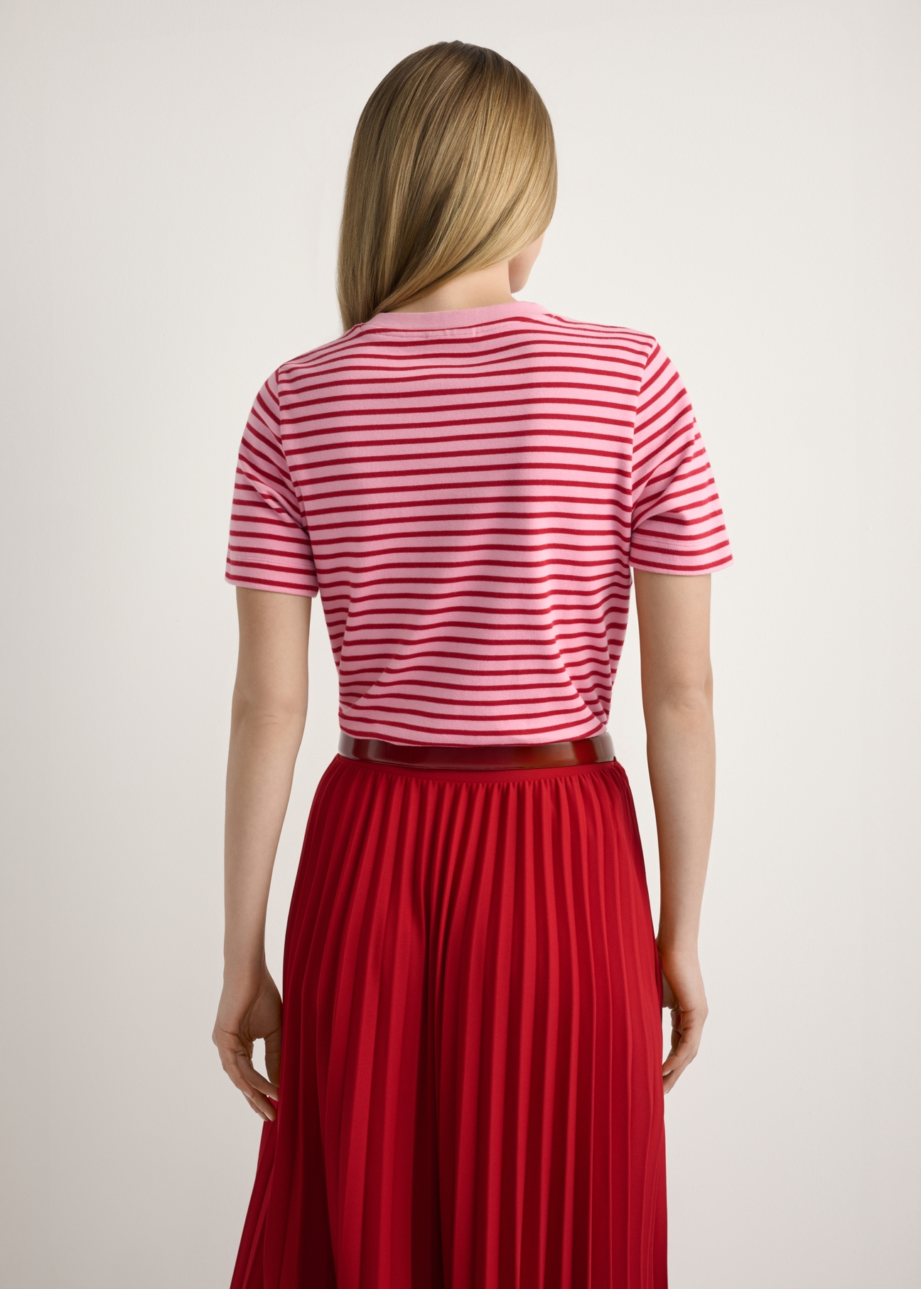 Różowy T-shirt damski w paski TSHDT-0150-5P(W26), widok produktu z tyłu na modelce. Widoczna połowa sylwetki.