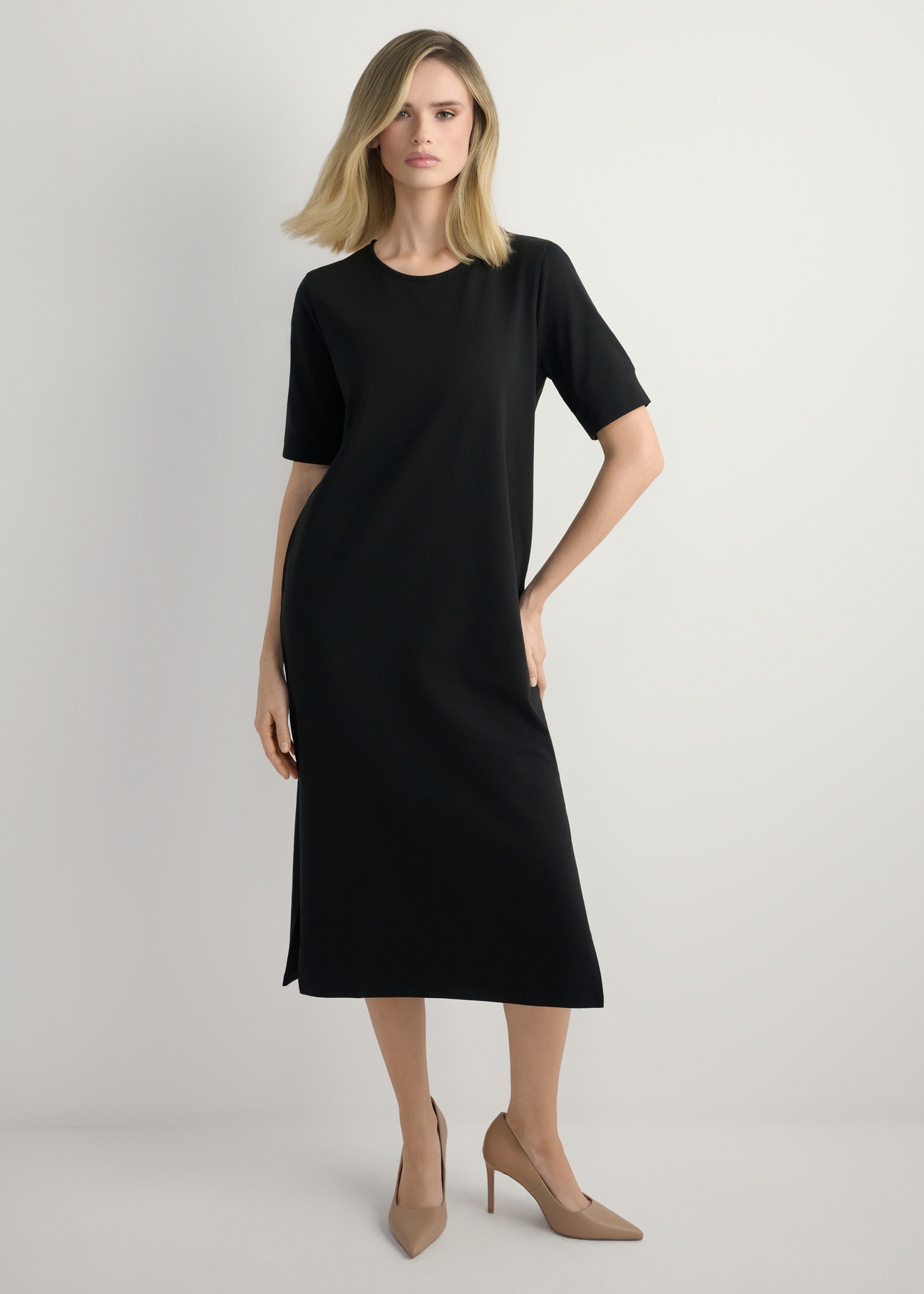 Czarna bawełniana sukienka midi SUKDT-0256-99(W26) - widok produktu z przodu, na modelce, na jasnym tle. Widoczna cała sylwetka. 