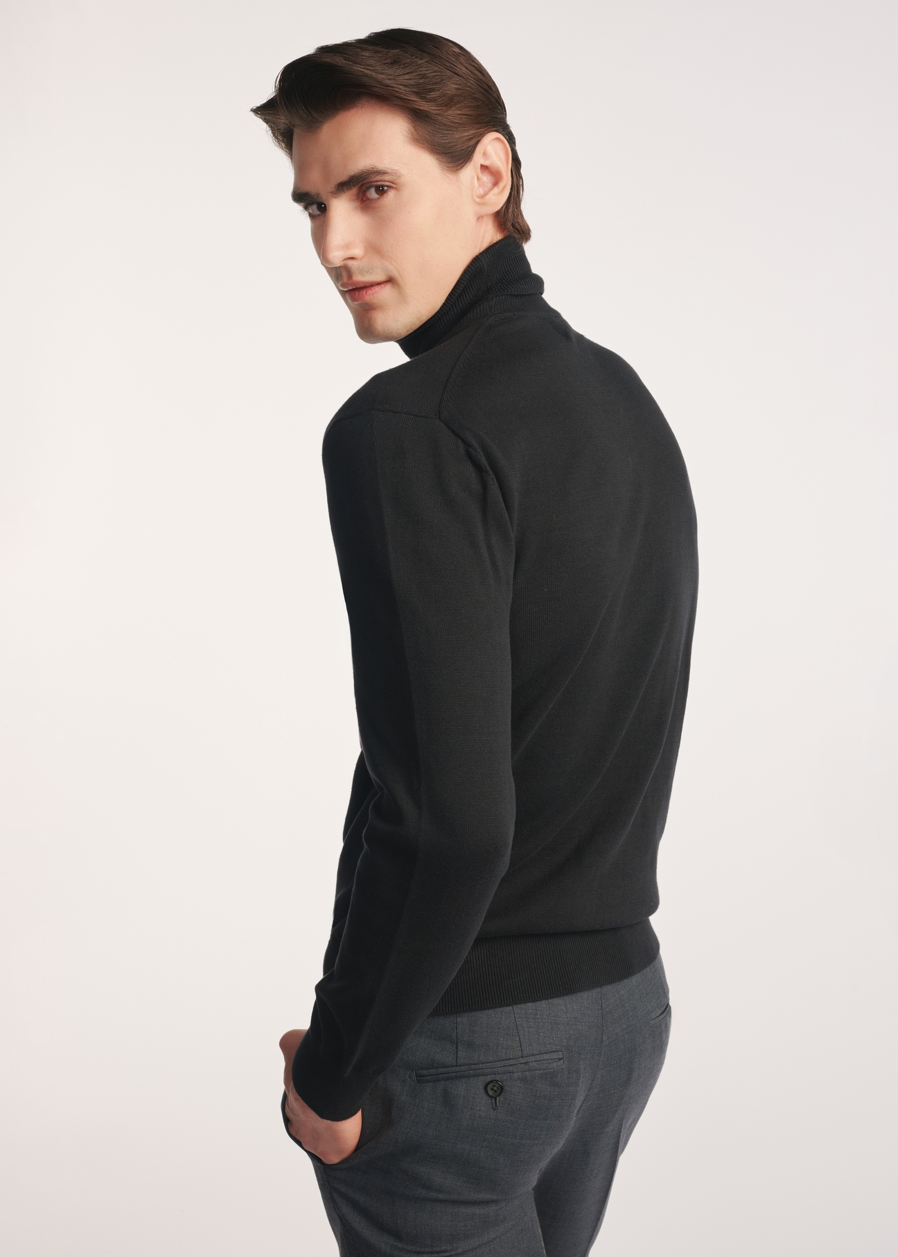 Czarny sweter męski z golfem SWEMT-0095B-99(Z25), produkt widoczny od tyłu na modelu, widoczne pół sylwetki.