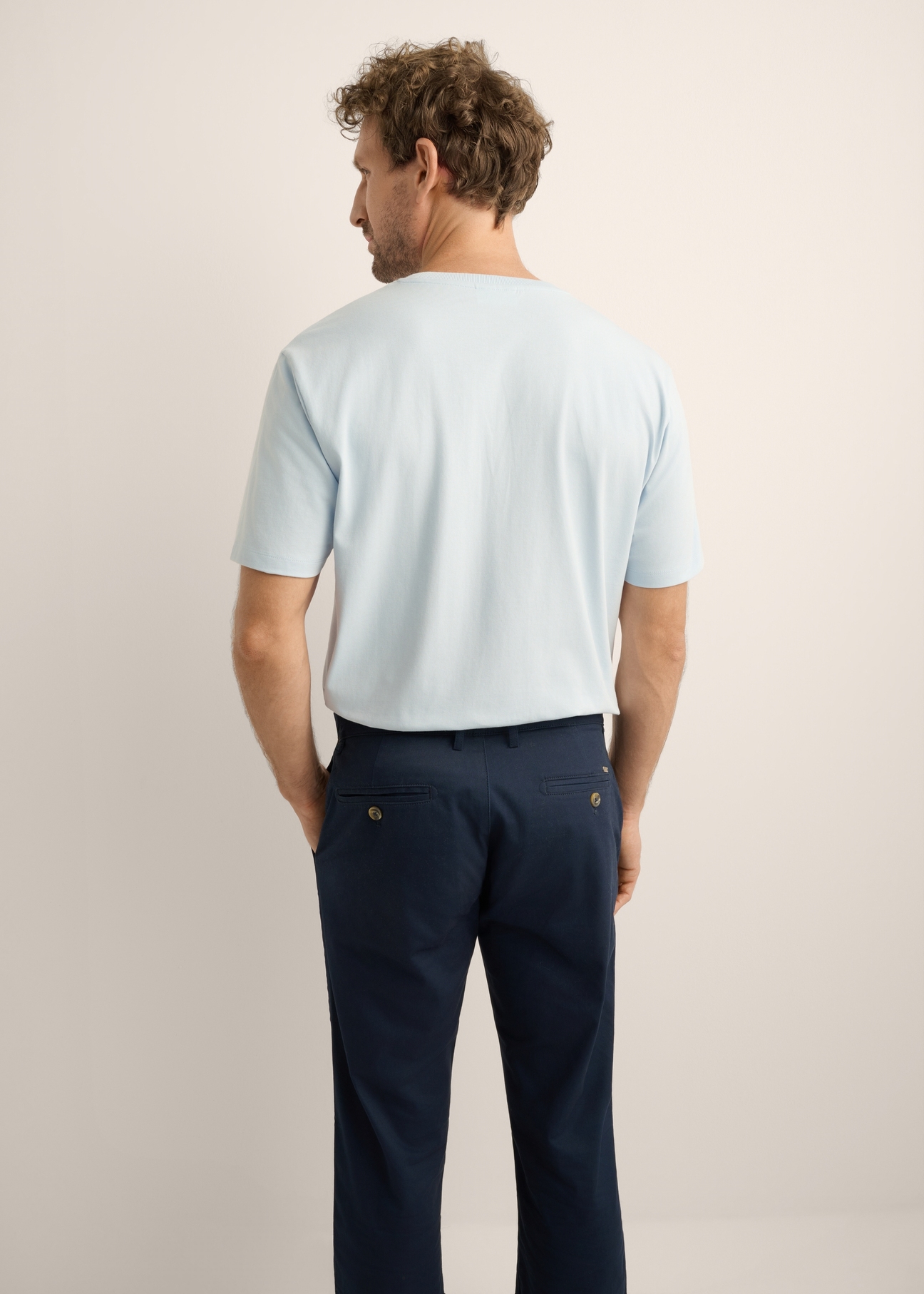 Jasnoniebieski T-shirt męski TSHMT-0120-7A(Z26). Widok produktu z tyłu na modelu. Widok na połowę sylwetki.
