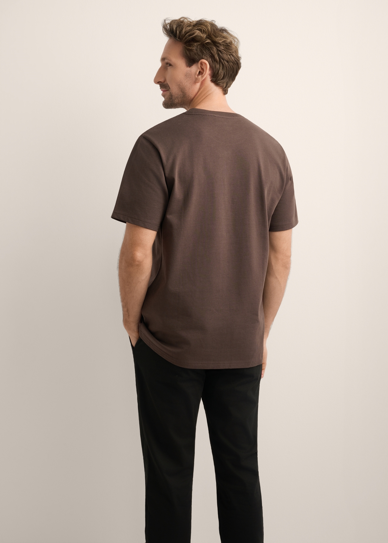 Brązowy bawełniany T-shirt męski z nadrukiem TSHMT-0152-1I(Z26), widok produktu z tyłu na modelu. Widoczna połowa sylwetki.