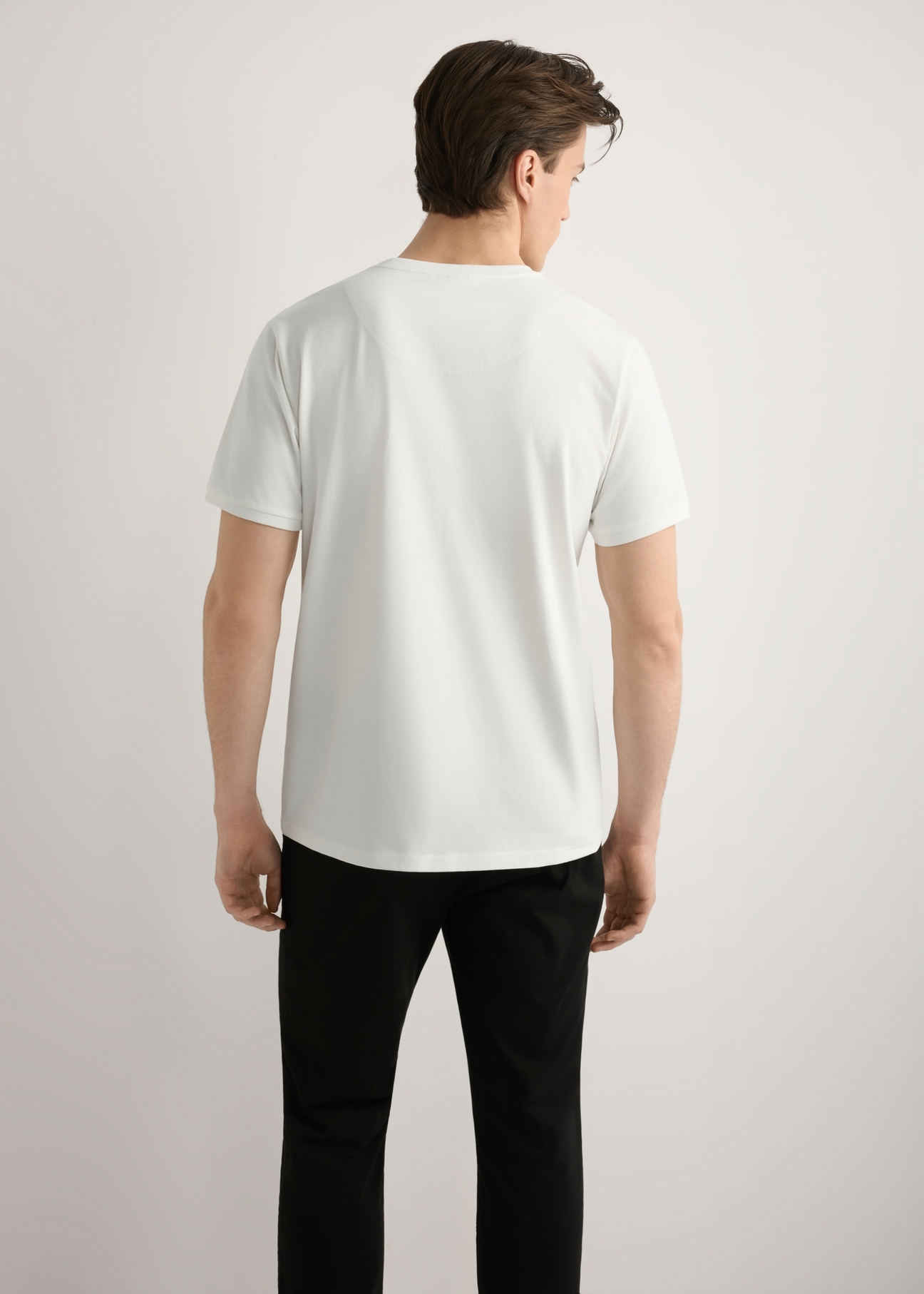 Biały bawełniany T-shirt męski TSHMT-0088-0B(W26), widok produktu od tyłu na modelu, widoczna połowa sylwetki.