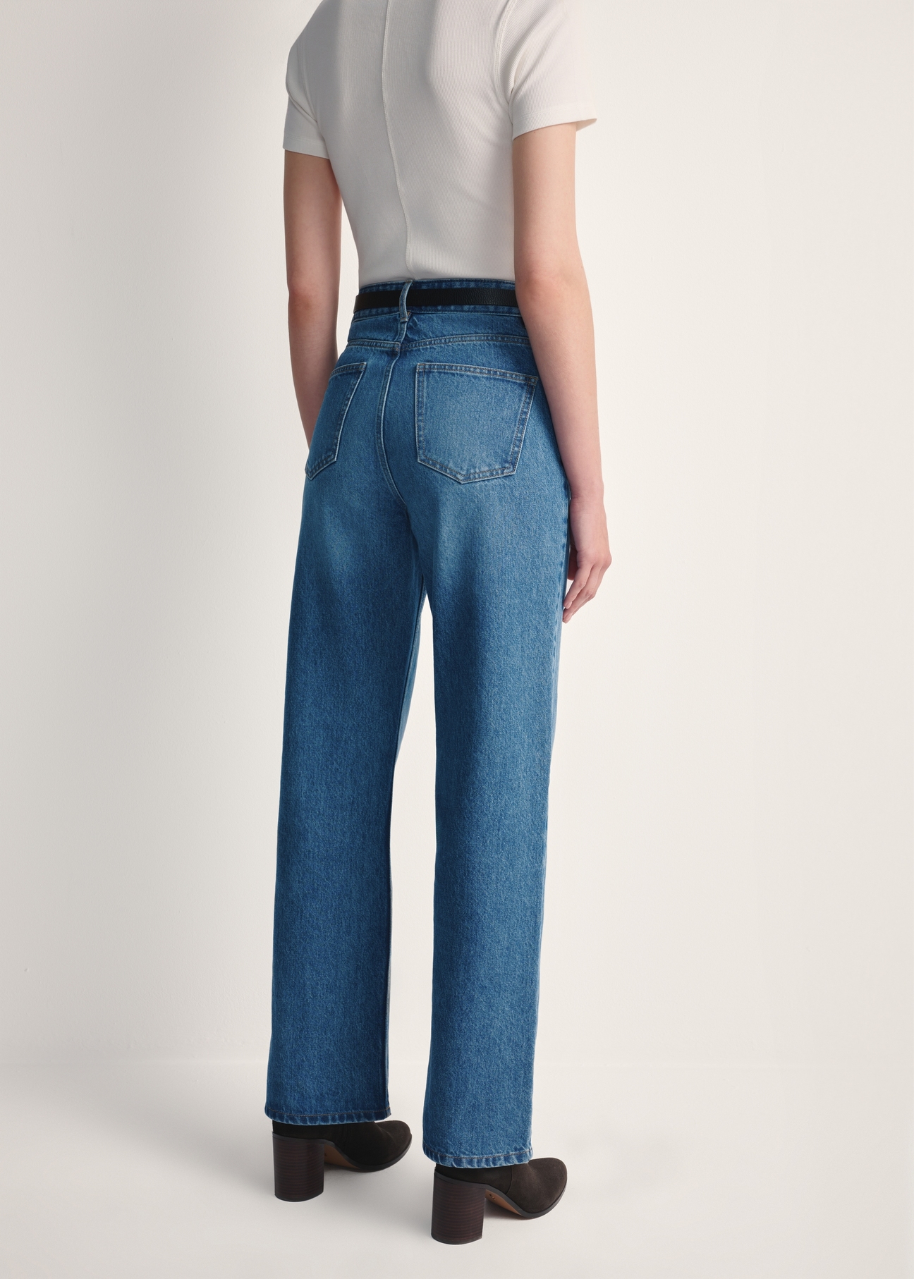 Niebieskie jeansowe spodnie damskie JEADT-0012-61(Z25), widok produktu z tyłu na modelce. Widoczna połowa sylwetki.