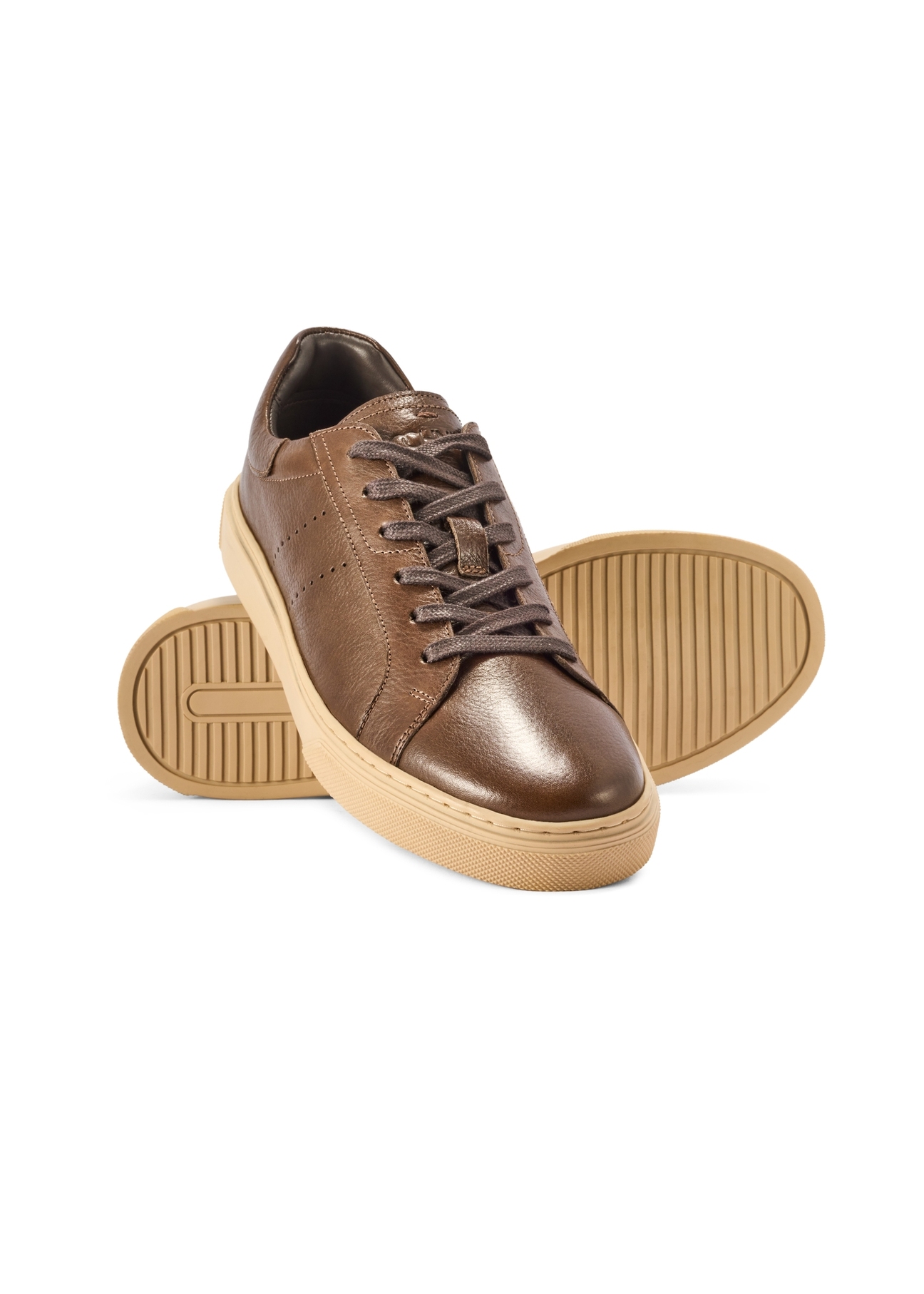 Ciemnobrązowe skórzane sneakersy męskie BUTYM-0486-1I(W26) - widok produktu lekko po skosie, na białym tle. 