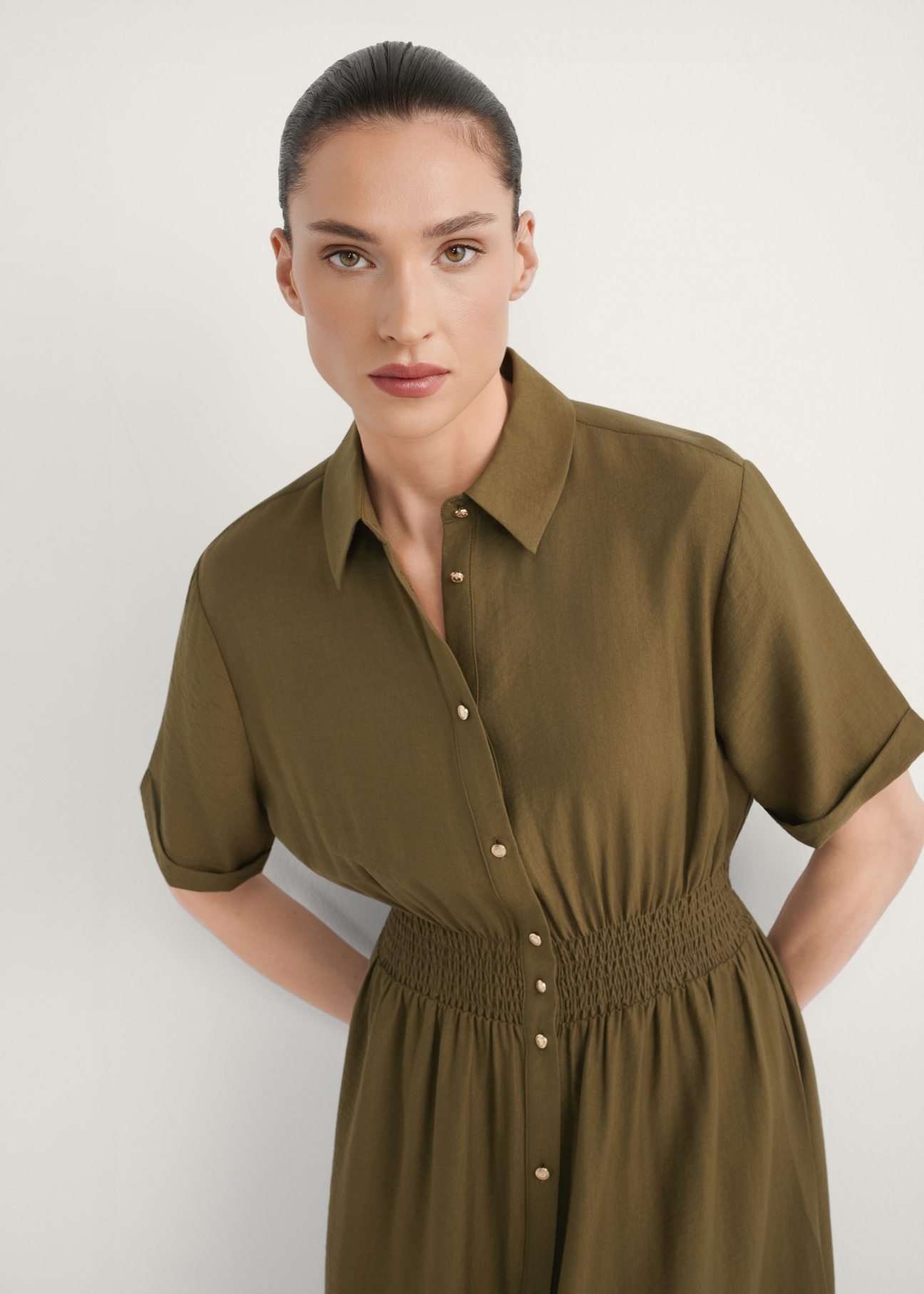 Sukienka midi w kolorze khaki SUKDT-0257-8D(W26), zbliżenie na produkt z przodu na modelce.