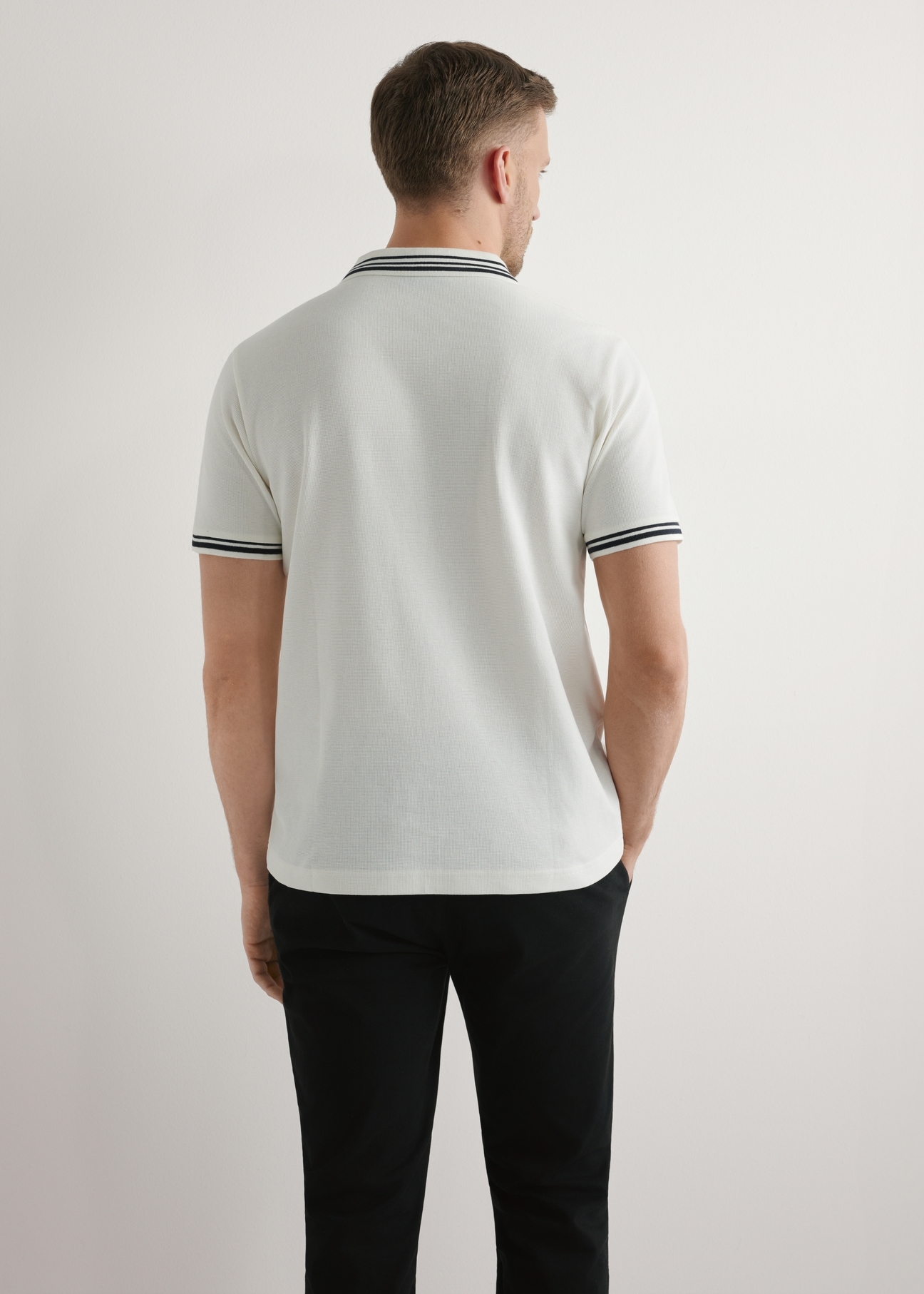 Kremowa męska koszulka polo POLMT-0091-0B(W26), widok produktu z tyłu na modelu. Widoczna połowa sylwetki.