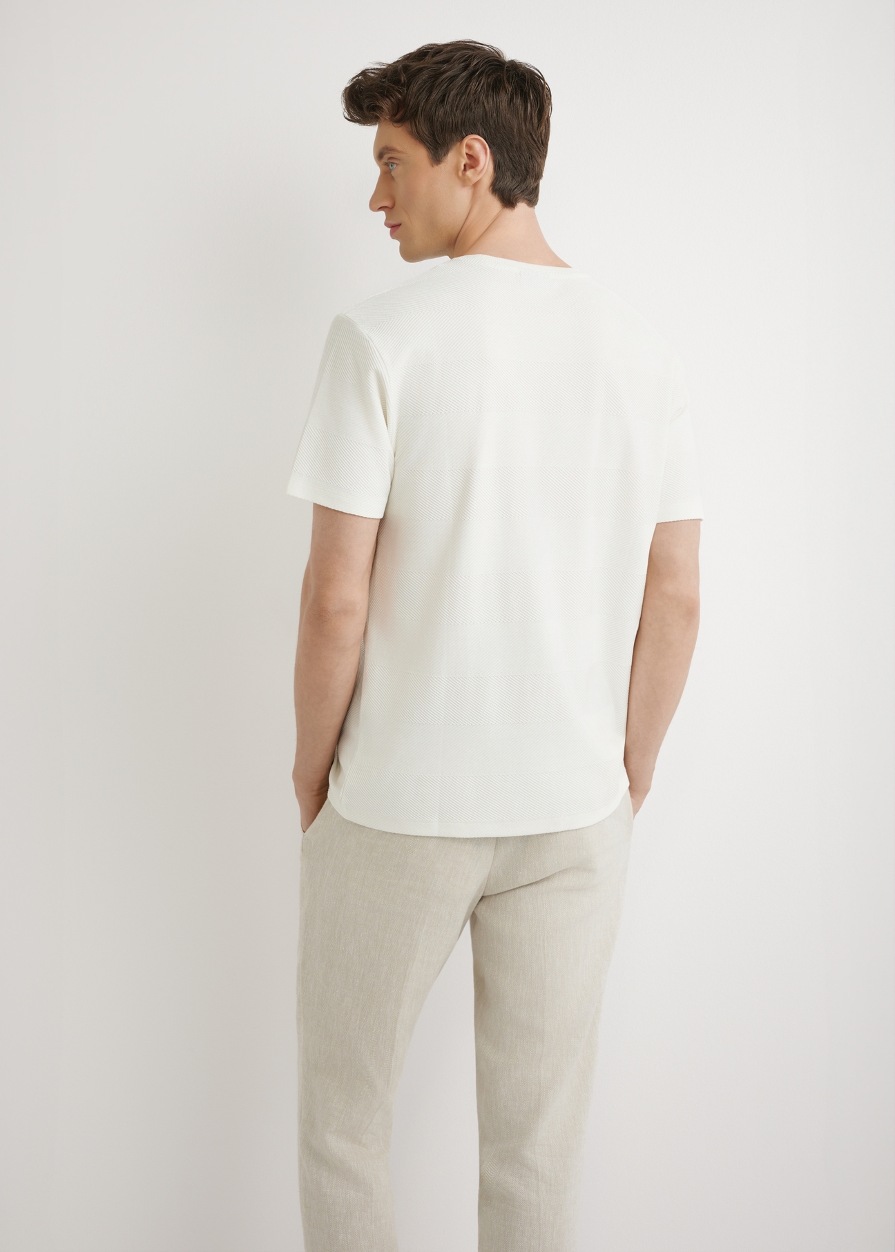 Kremowy prążkowany t-shirt męski TSHMT-0142-0B(W26) - widok produktu z tyłu, na modelu, na jasnym tle. Widoczna sylwetka do połowy.