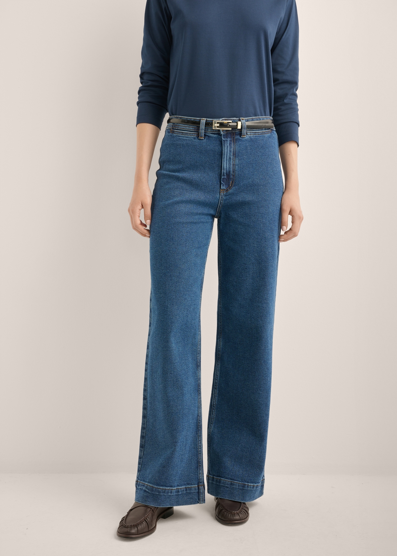 Damskie jeansy wide leg w kolorze ciemnogranatowym JEADT-0019-7D(Z26), widok produktu z przodu na modelce. Widoczna połowa sylwetki.