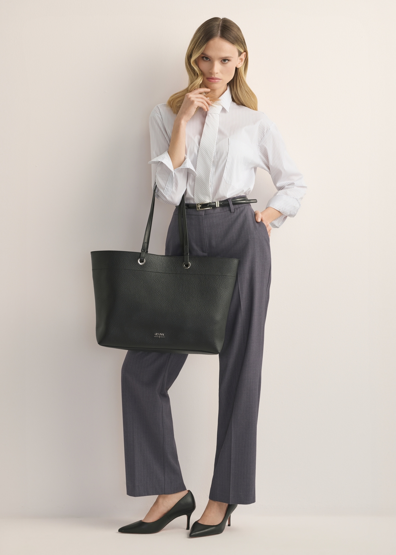 Czarna groszkowana torebka shopper TOREC-1252-9I(Z26), widok produktu z przodu na modelce. Widoczna cała sylwetka. 