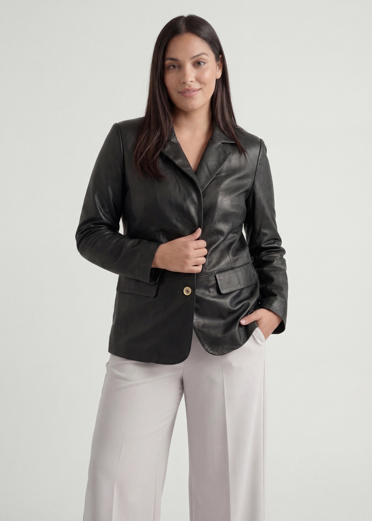 Czarna skórzana marynarka damska PLUS SIZE KURDS-0645L-99(W26), widok produktu od przodu na modelce, widoczna połowa sylwetki.