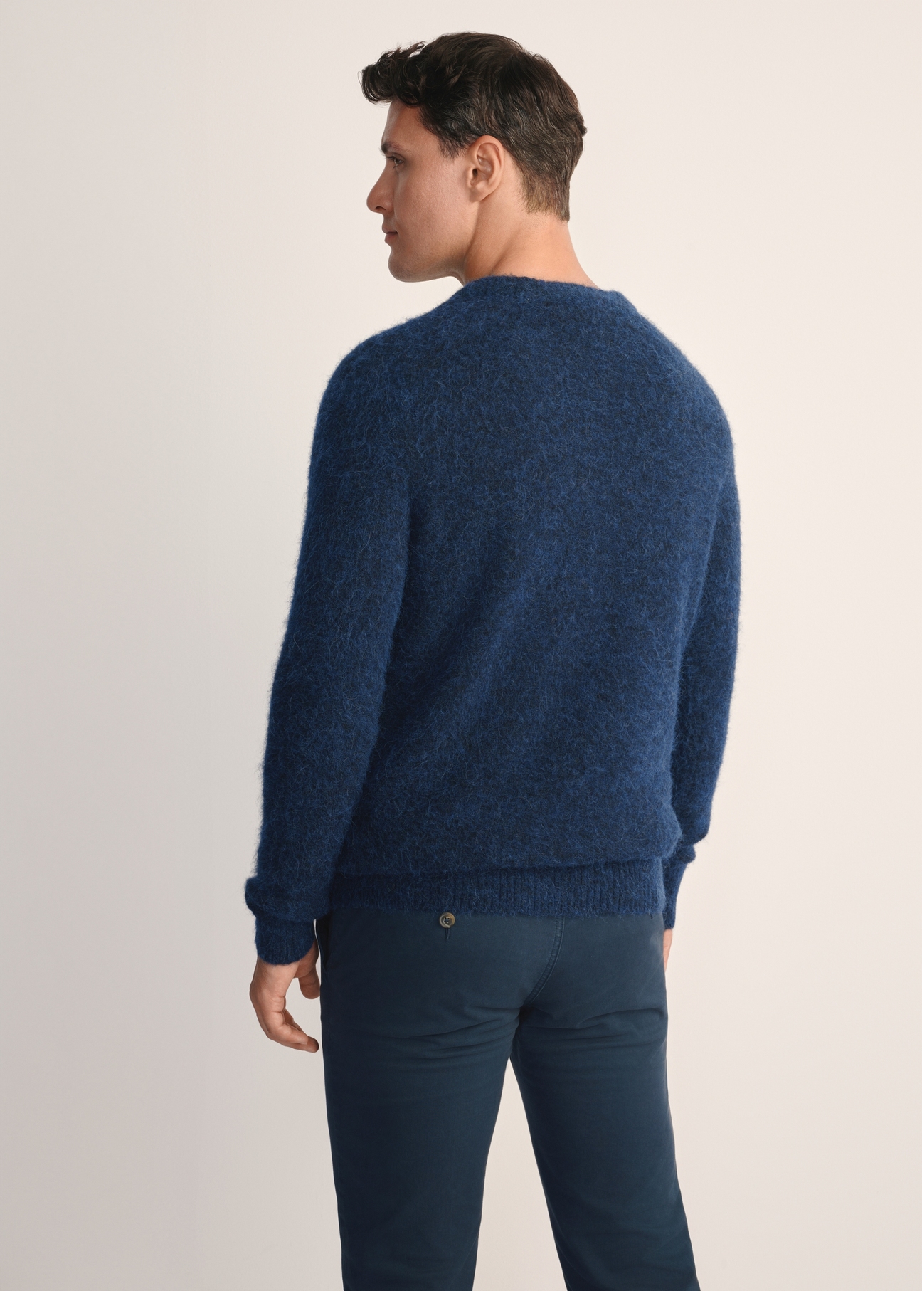 Granatowy sweter męski z wełną SWEMT-0171-68(Z25), widok produktu z tyłu na modelu. Widoczna połowa sylwetki.