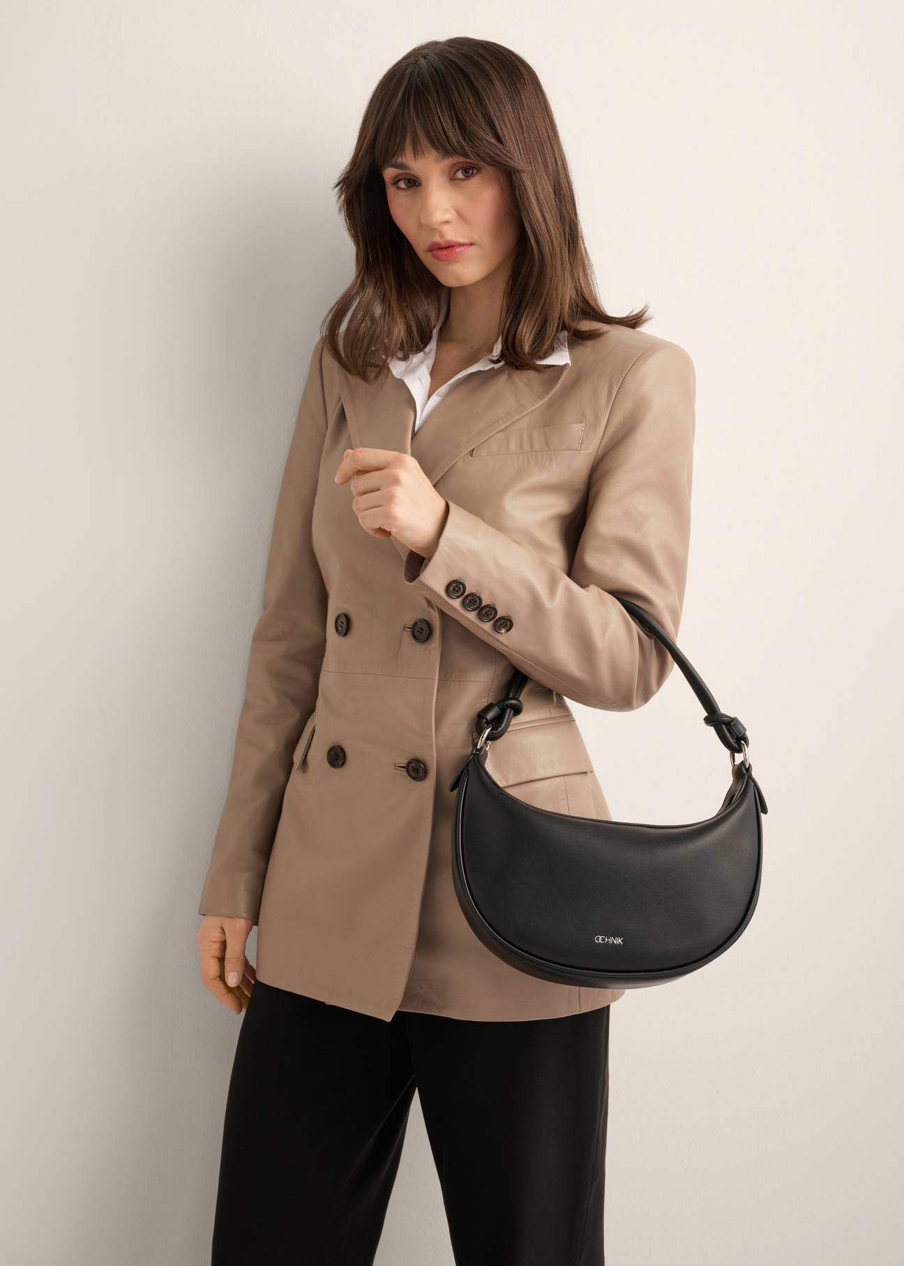 Czarna mała torebka damska hobo TOREC-1097-99(Z26), widok produktu na ramieniu modelki. Widoczna połowa sylwetki.