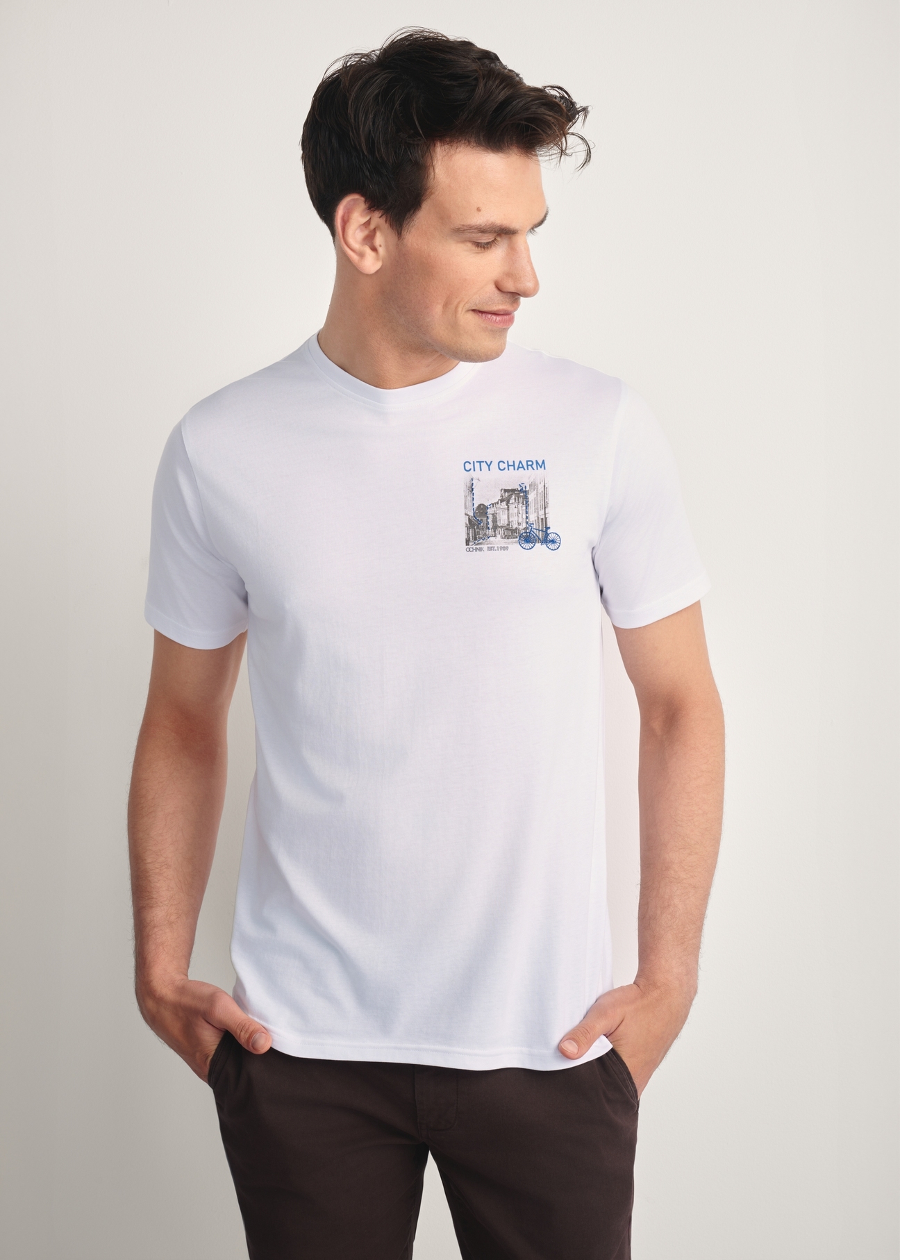 Biały T-shirt męski z nadrukiem TSHMT-0133-11(Z25), widok produktu z przodu na modelu. Widoczna połowa sylwetki.