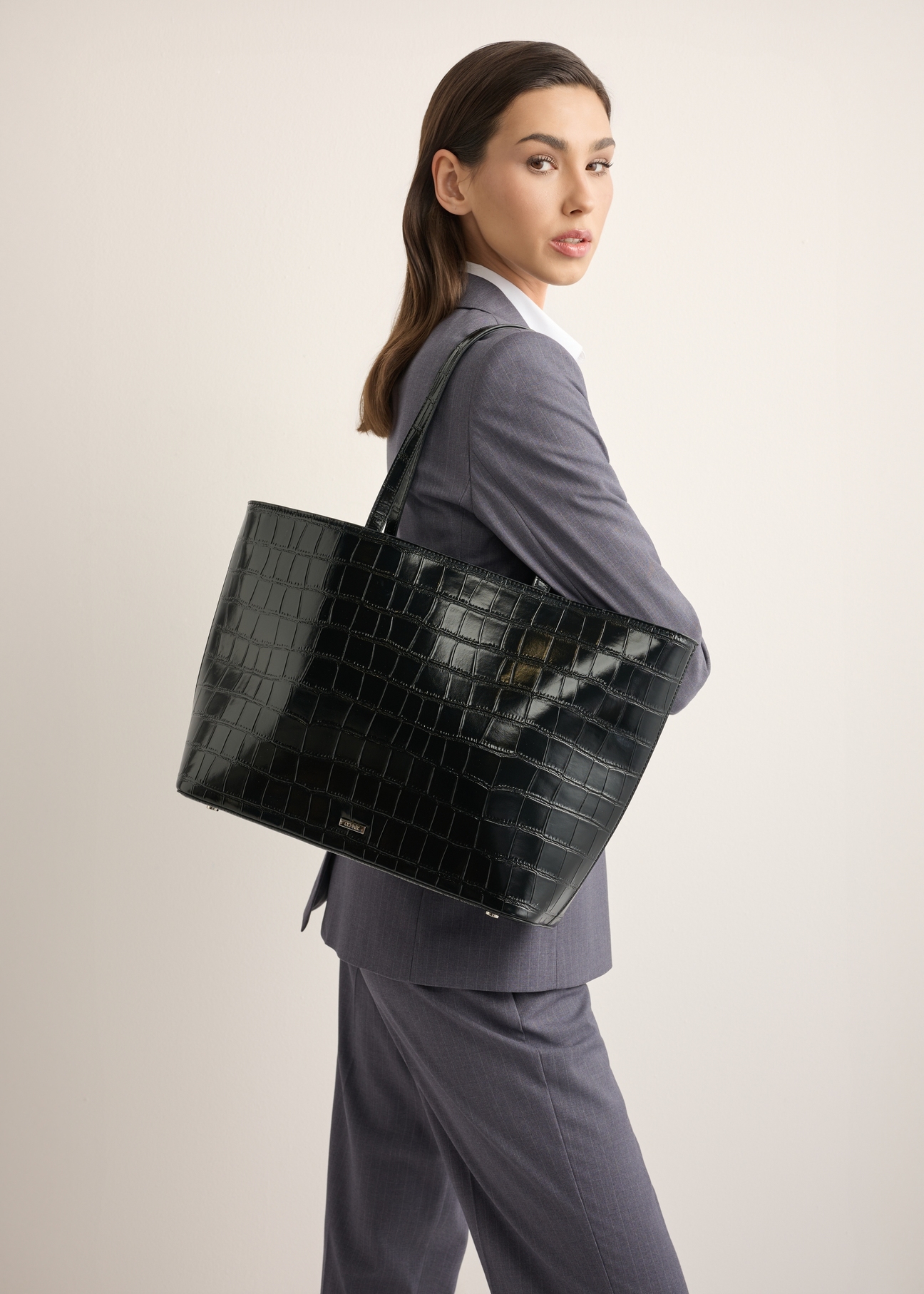 Czarna torebka shopper croco TOREC-1242-9G(Z26), widok z przodu na modelce. Widoczna połowa sylwetki. 