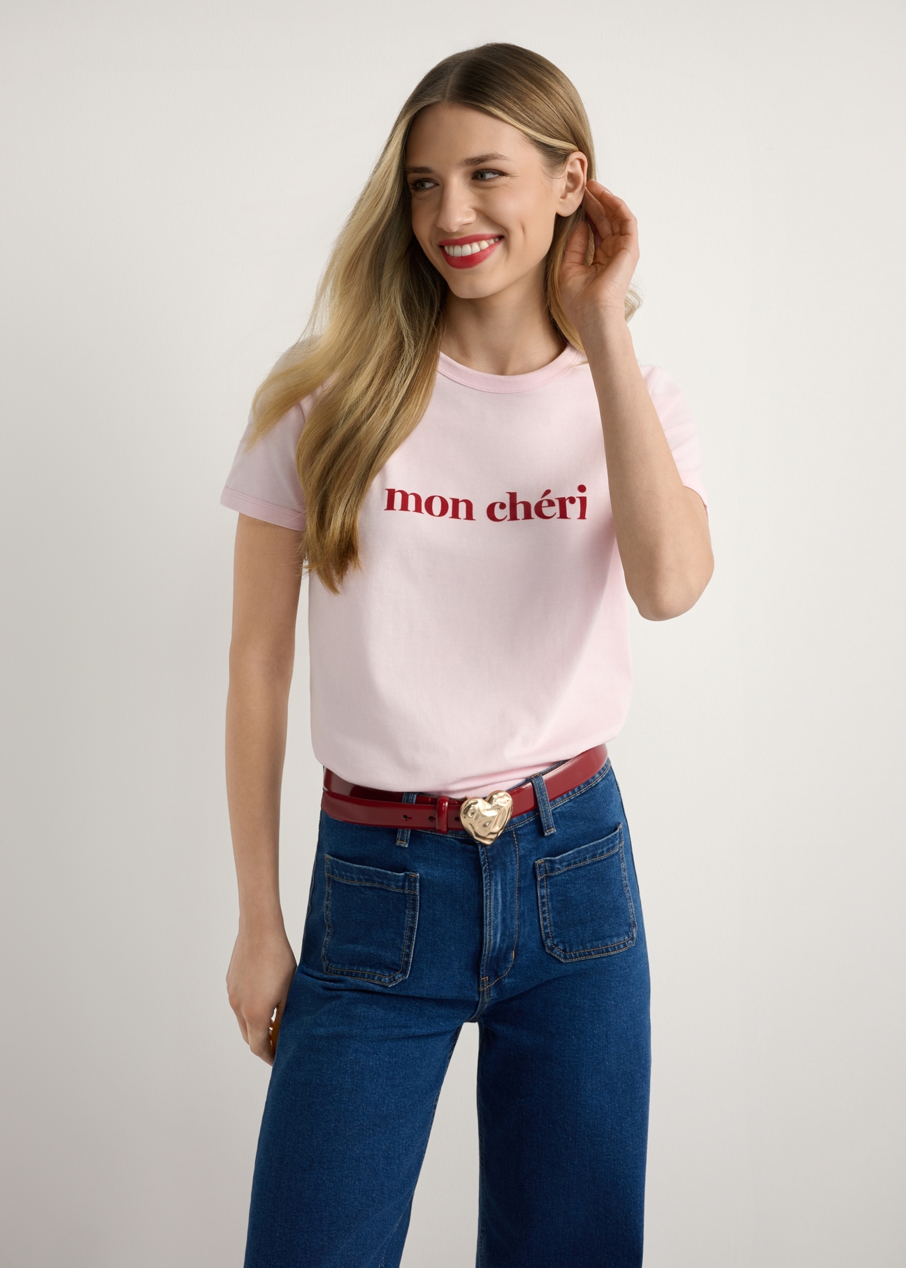 Różowy T-shirt damski z nadrukiem TSHDT-0152-5A(W26), widok produktu od przodu na modelce, widoczna połowa sylwetki.