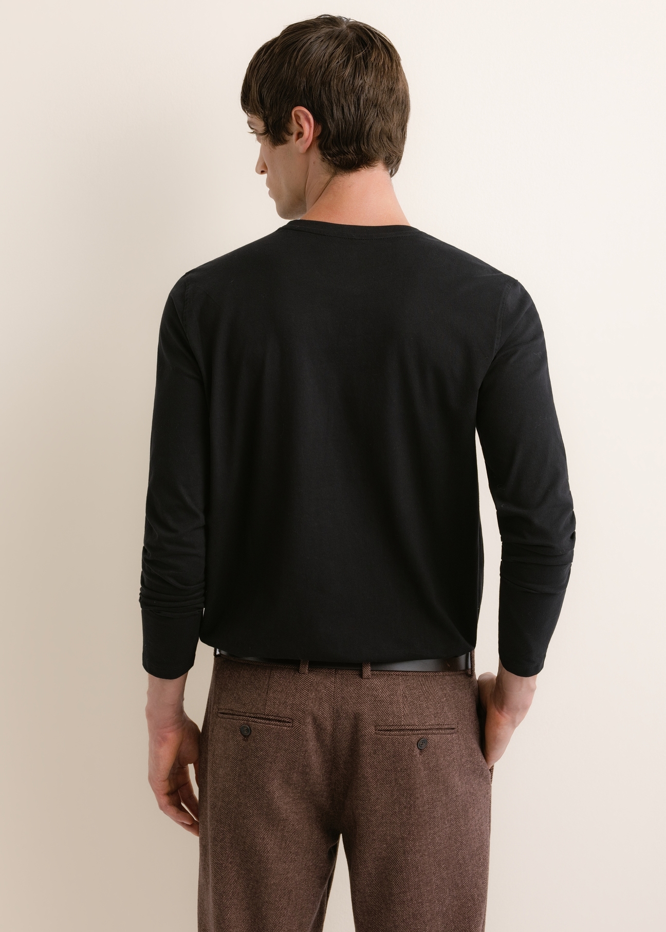Czarny bawełniany longsleeve męski LSLMT-0013-99(Z26), widok produktu z tyłu na modelu. Widoczna połowa sylwetki.