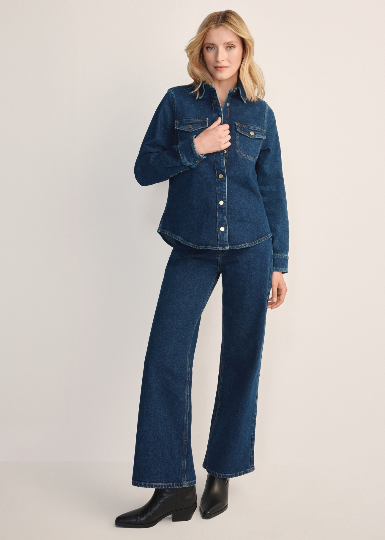 Granatowe jeansowe spodnie damskie JEADT-0013-69(Z25), widok produktu z przodu na modelce. Widoczna cała sylwetka.