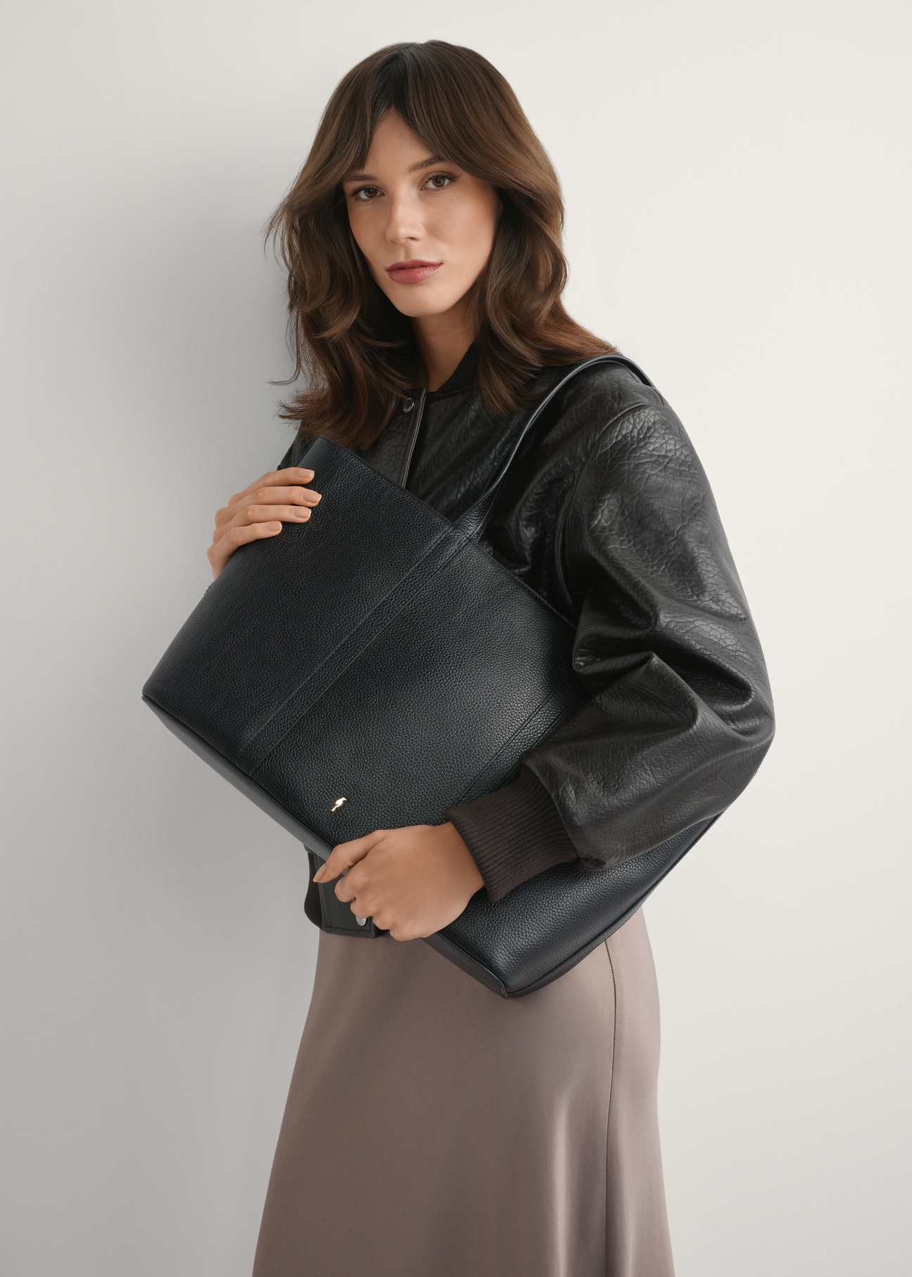 Czarna skórzana torebka shopper TORES-1273-9I(W26), widok produktu na ramieniu modelki. Widoczna połowa sylwetki.