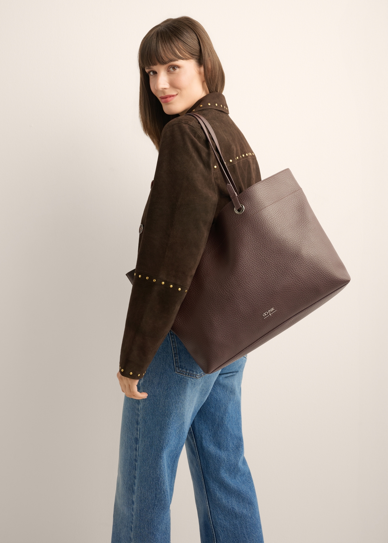 Brązowa groszkowana torebka shopper TOREC-1252-1I (Z26), widok produktu od przodu na modelce. Widoczna połowa sylwetki.