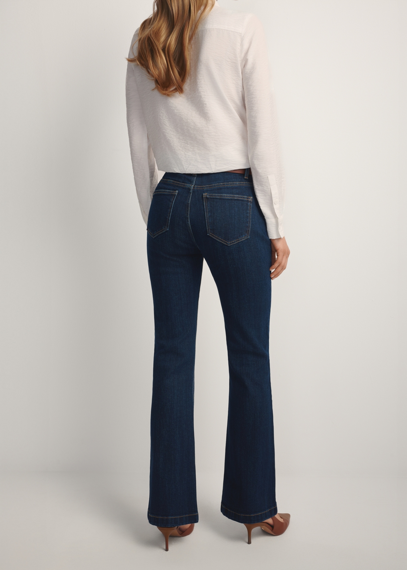 Granatowe jeansy wide leg JEADT-0015-7H(W26) - widok produktu z tyłu, na modelce, na jasnym tle. Widoczna połowa sylwetki.