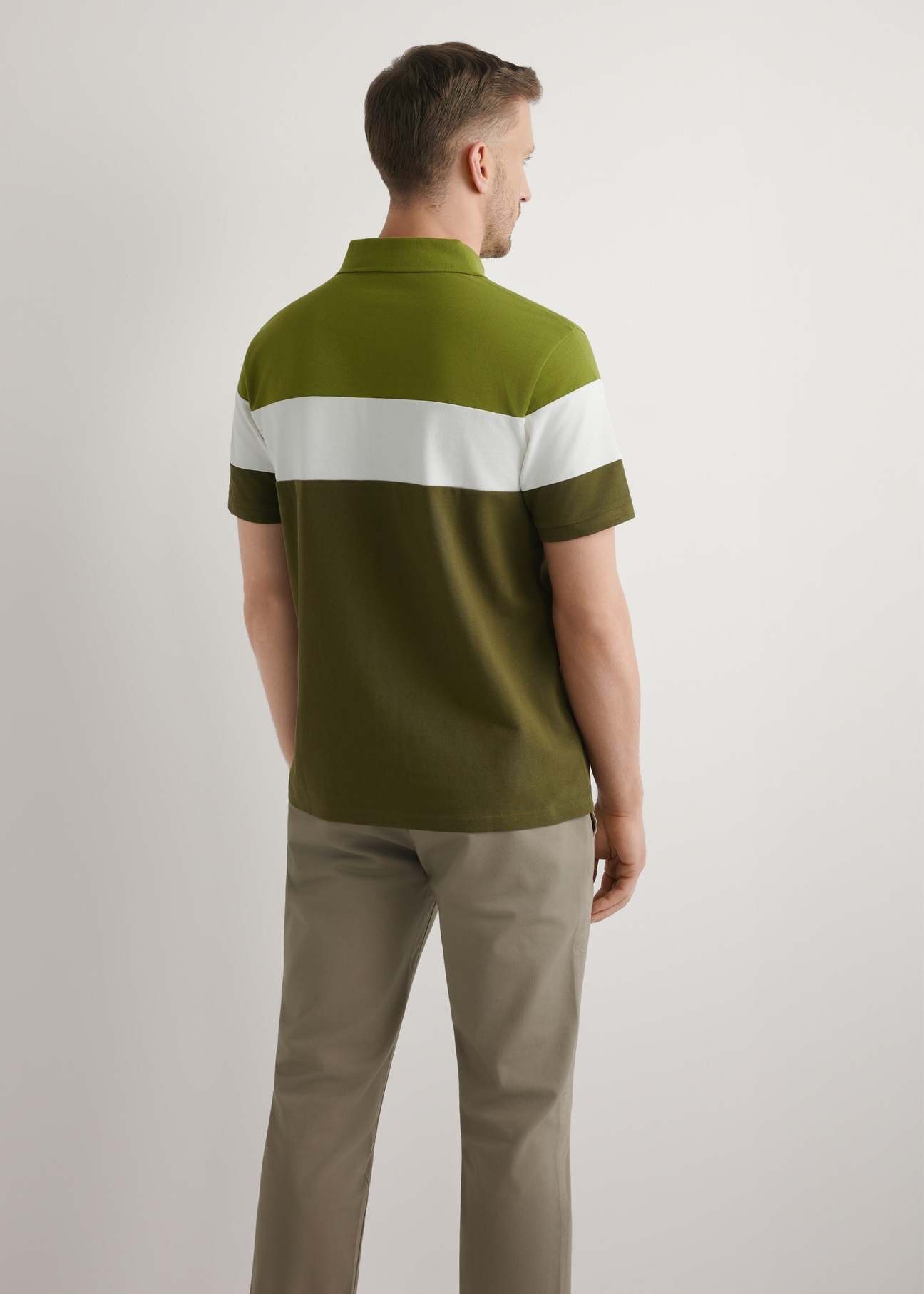 Zielona bawełniana koszulka polo męska POLMT-0087-8E(W26), widok produktu z tyłu na modelu. Widoczna połowa sylwetki.