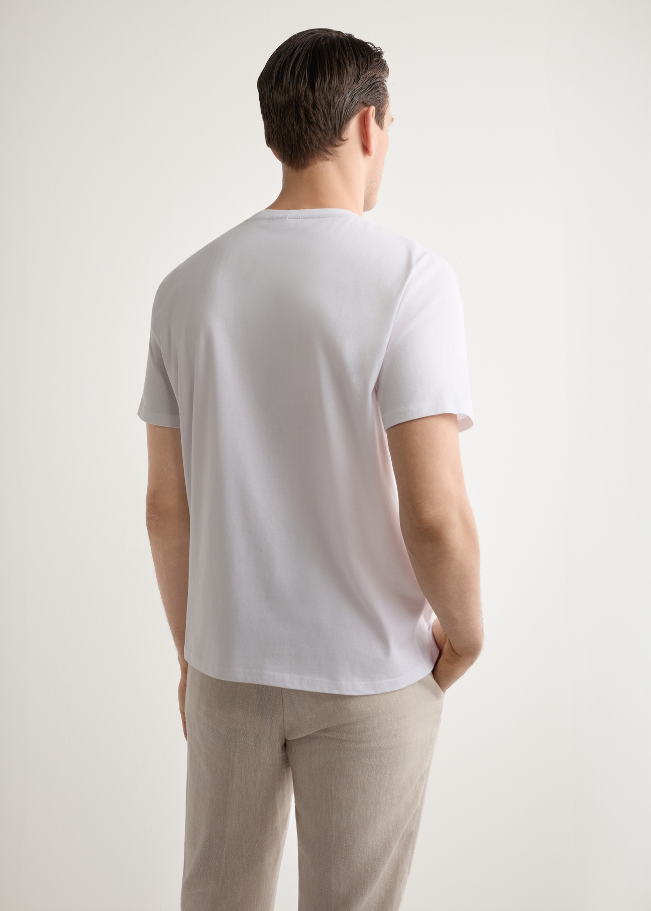 Biały T-shirt męski z nadrukiem TSHMT-0151-0B(W26), widok produktu z tyłu na modelu. Widoczna połowa sylwetki.