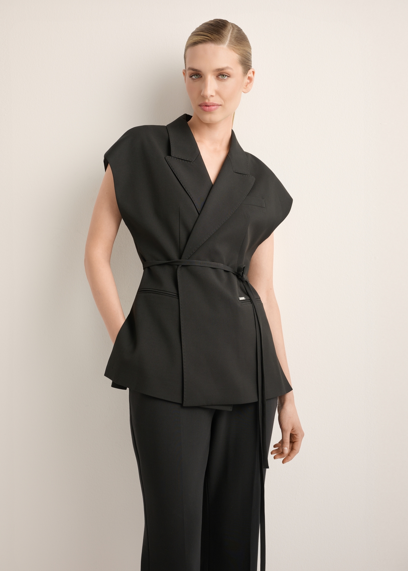 Czarna kamizelka garniturowa damska oversize KAMDT-0039-99(Z26), widok produktu z przodu na modelce. Widoczna połowa sylwetki.