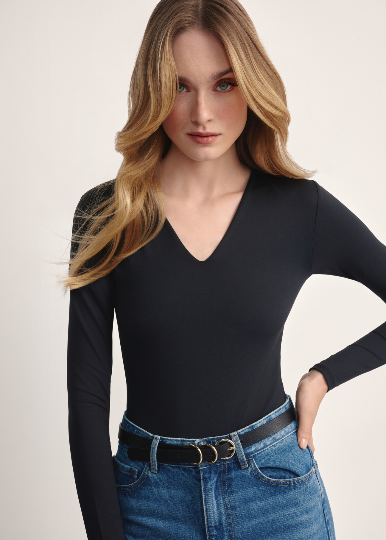 Czarne body damskie z długim rękawem BODYT-0001-99(Z25), produkt widoczny od przodu na modelce, zbliżenie na detal produktu.
