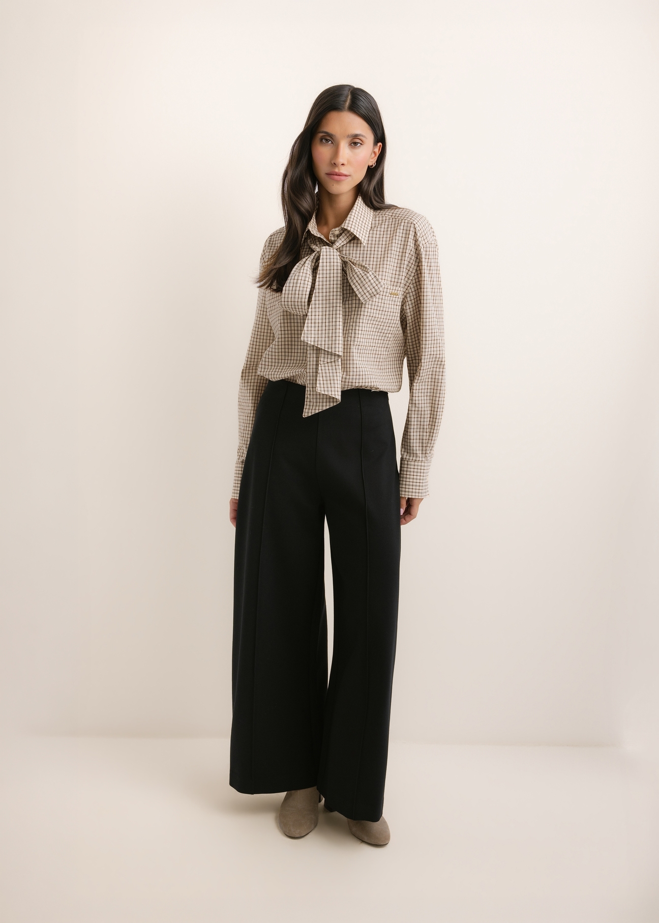Czarne spodnie damskie wide leg SPODT-0130-99(Z26), widok produktu z przodu na modelce. Widoczna cała sylwetka.