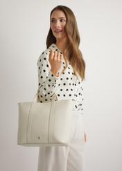 Kremowa skórzana torebka shopper TORES-1272-0B(W26) - widok torebki, trzymanej przez modelkę w ręku, na jasnym tle. 