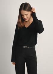 Czarny sweter z dekoltem V-neck SWEDT-0201-99(W24), widok produktu od przodu na modelce, widoczna połowa sylwetki.