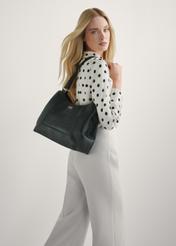 Czarna skórzana torebka shopper damska TORES-1264-9I(W26), widok produktu na ramieniu modelki. Widoczna połowa sylwetki.