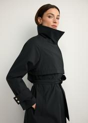 Czarny długi płaszcz damski KURDT-0653-99(W26), zbliżenie na produkt na sylwetce modelki.